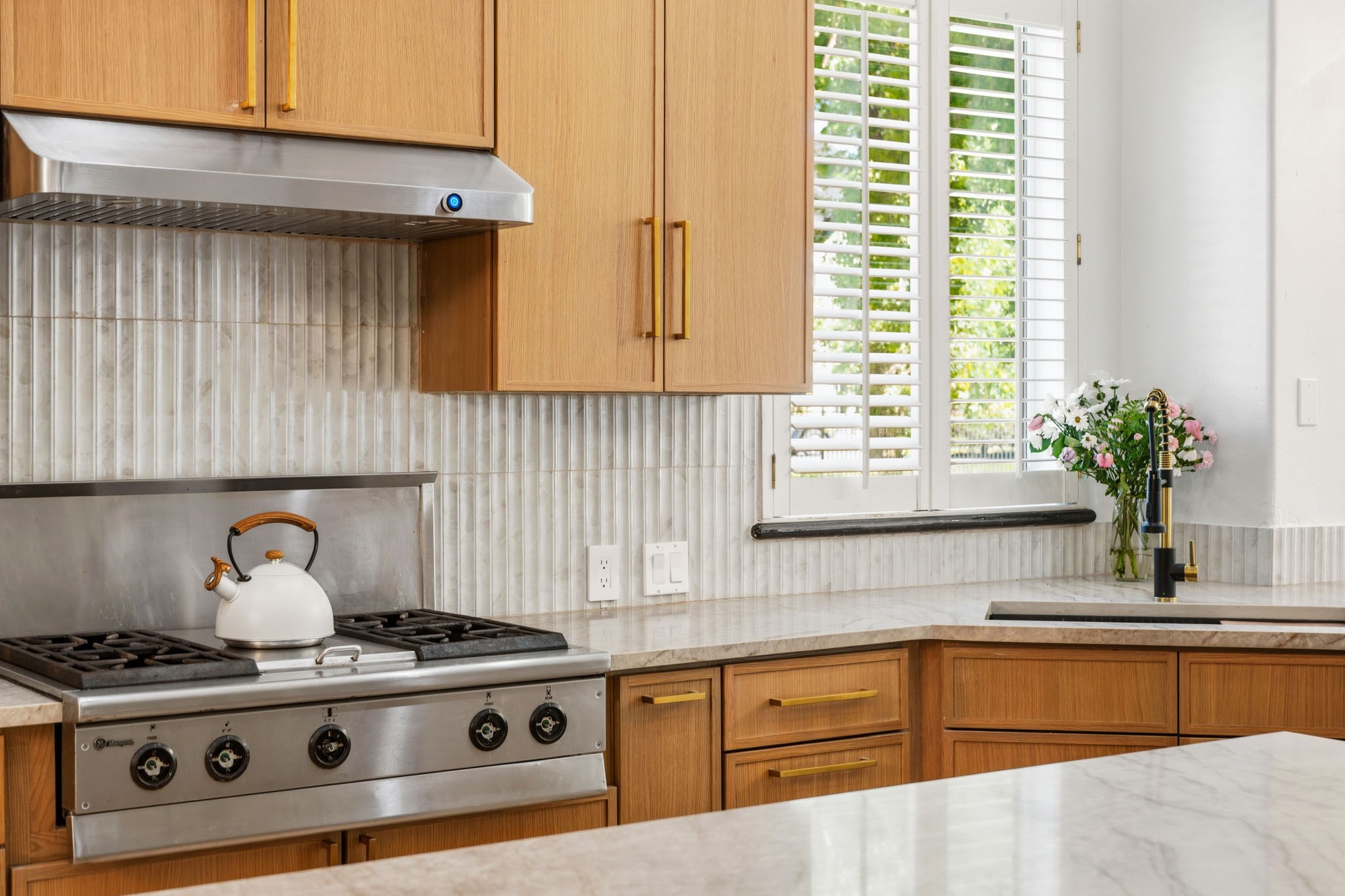 Designer kitchen with COMMERCIAL-STYLE GAS RANGE, and STAINLESS VENT HOOD.