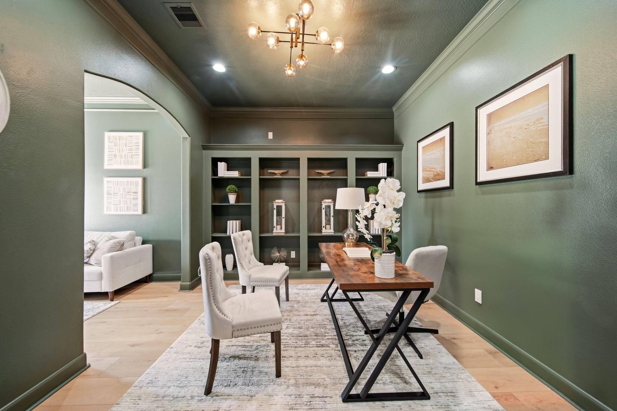 Spacious study featuring custom cabinetry, elevated lighting, and flexible workspace design.