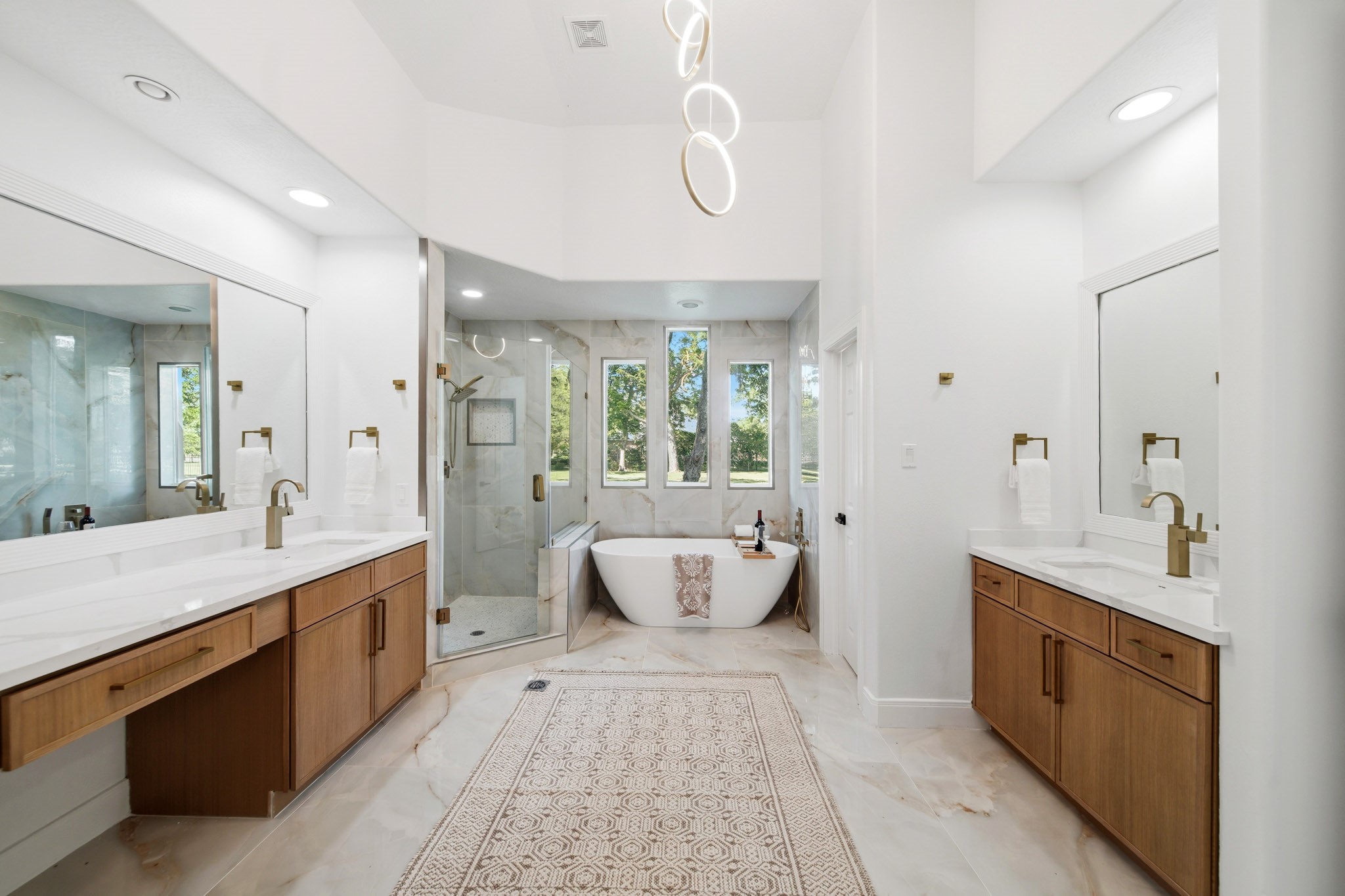 Stunning spa-like primary bath with dual vanities, soaking tub, and oversized walk-in shower.