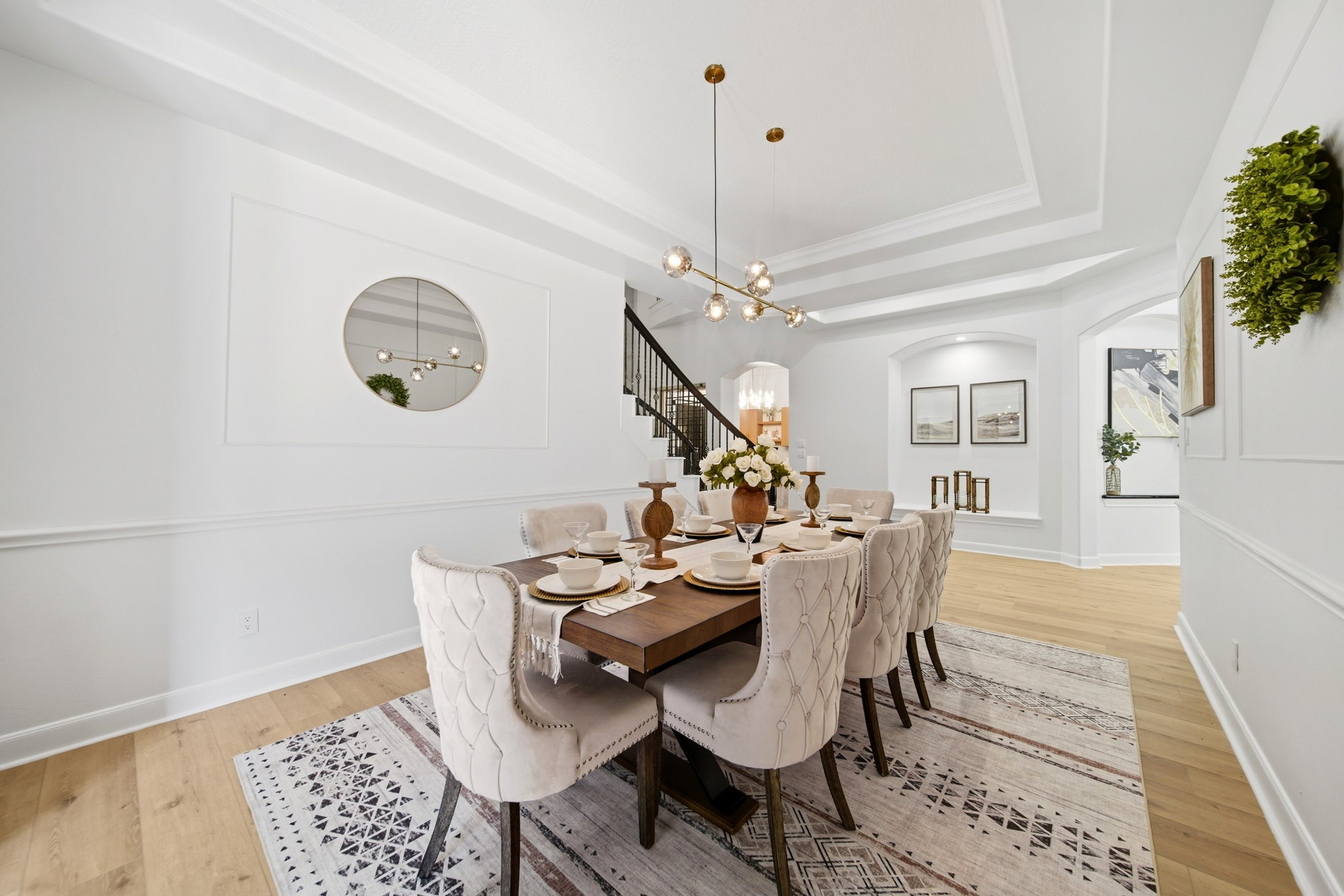 Formal dining room with tray ceilings, designer lighting, and sophisticated architectural detailing.