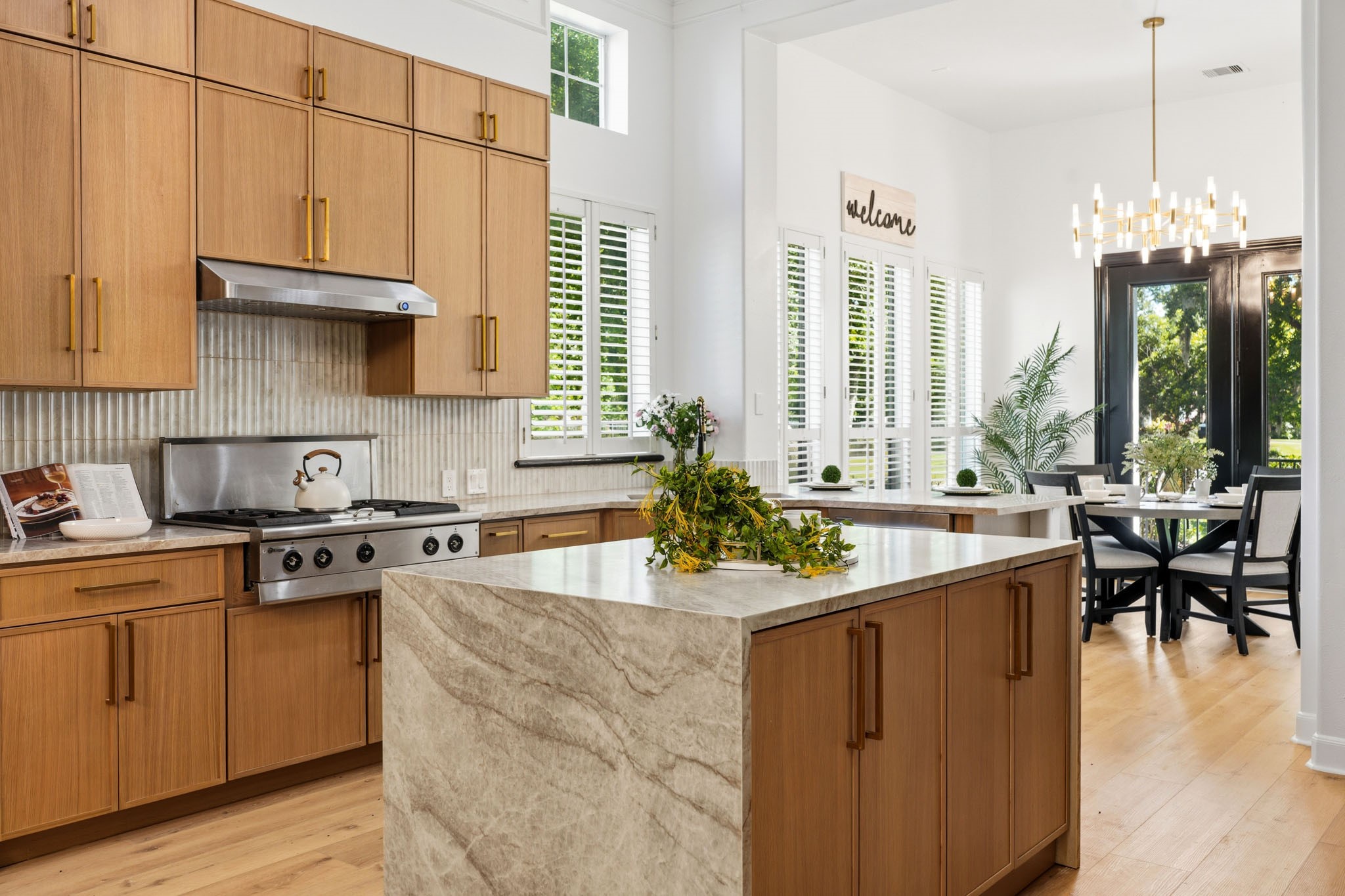 Designer KITCHEN showcases a dramatic stone waterfall island, custom cabinetry, premium appliances, and extensive recent upgrades throughout.