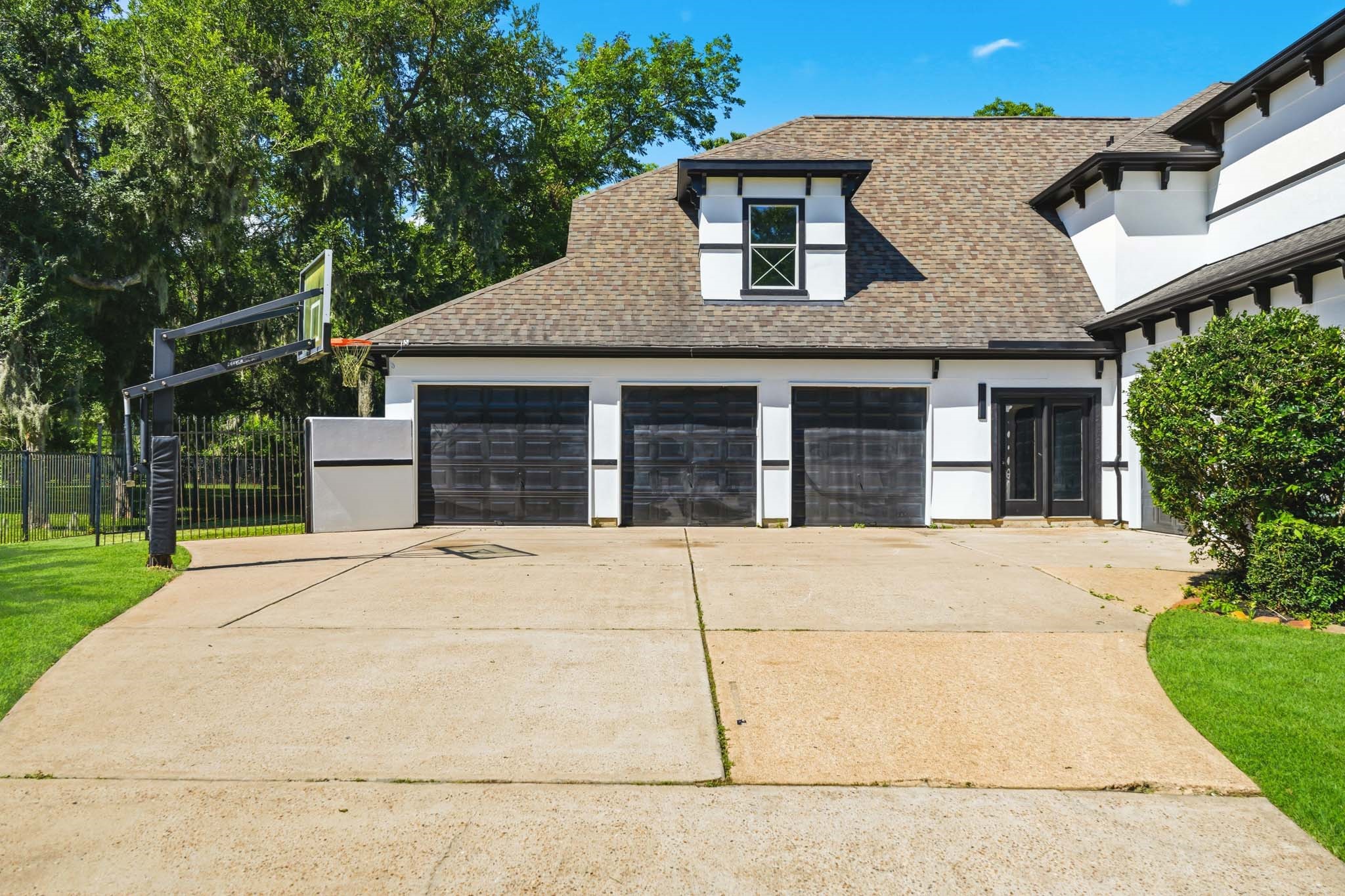 Striking MODERN CUSTOM EXTERIOR with mature trees, fresh finishes, and a spacious FOUR-CAR GARAGE.