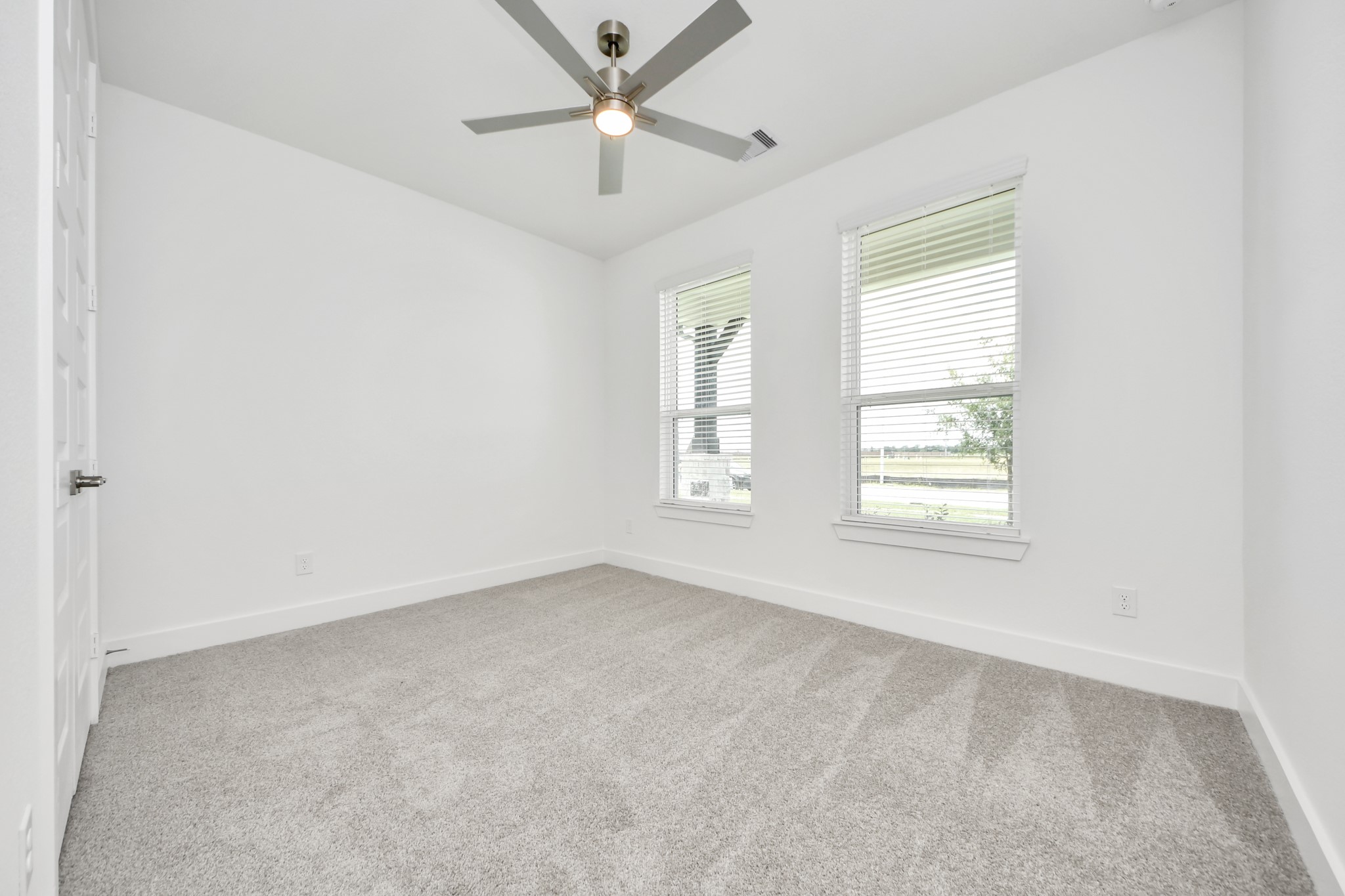 Secondary bedroom features plush carpeting, large windows that let in plenty of natural light, bright paint, and spacious closets. Sample photo of completed home with similar floor plan. Actual colors and selections may vary.