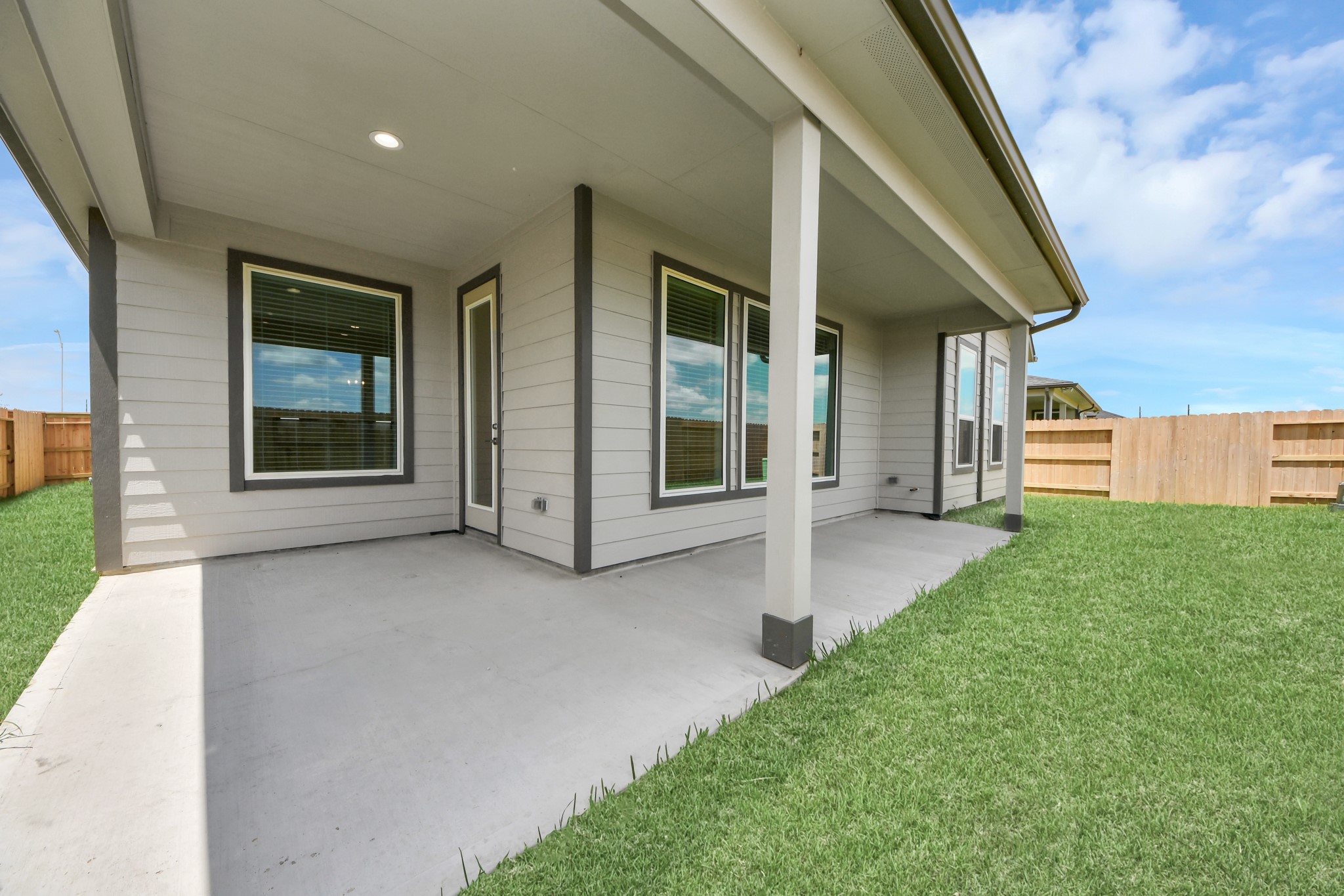 Experience outdoor living at its finest on this expansive covered patio, thoughtfully designed for BBQs and delightful outdoor dining. Sample photo of completed home with similar floor plan. Actual colors and selections may vary.