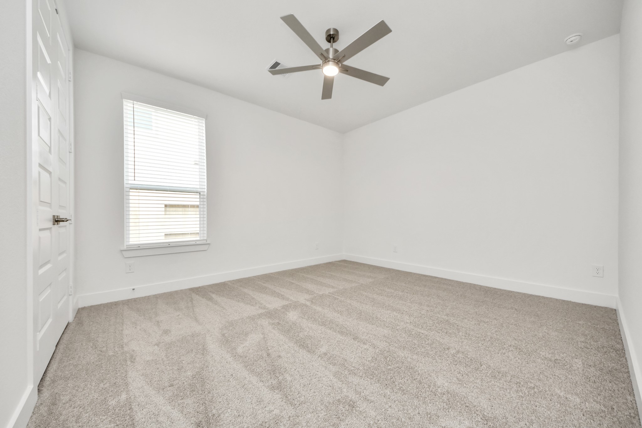 Secondary bedroom features plush carpeting, large windows that let in plenty of natural light, bright paint, and spacious closets. Sample photo of completed home with similar floor plan. Actual colors and selections may vary.