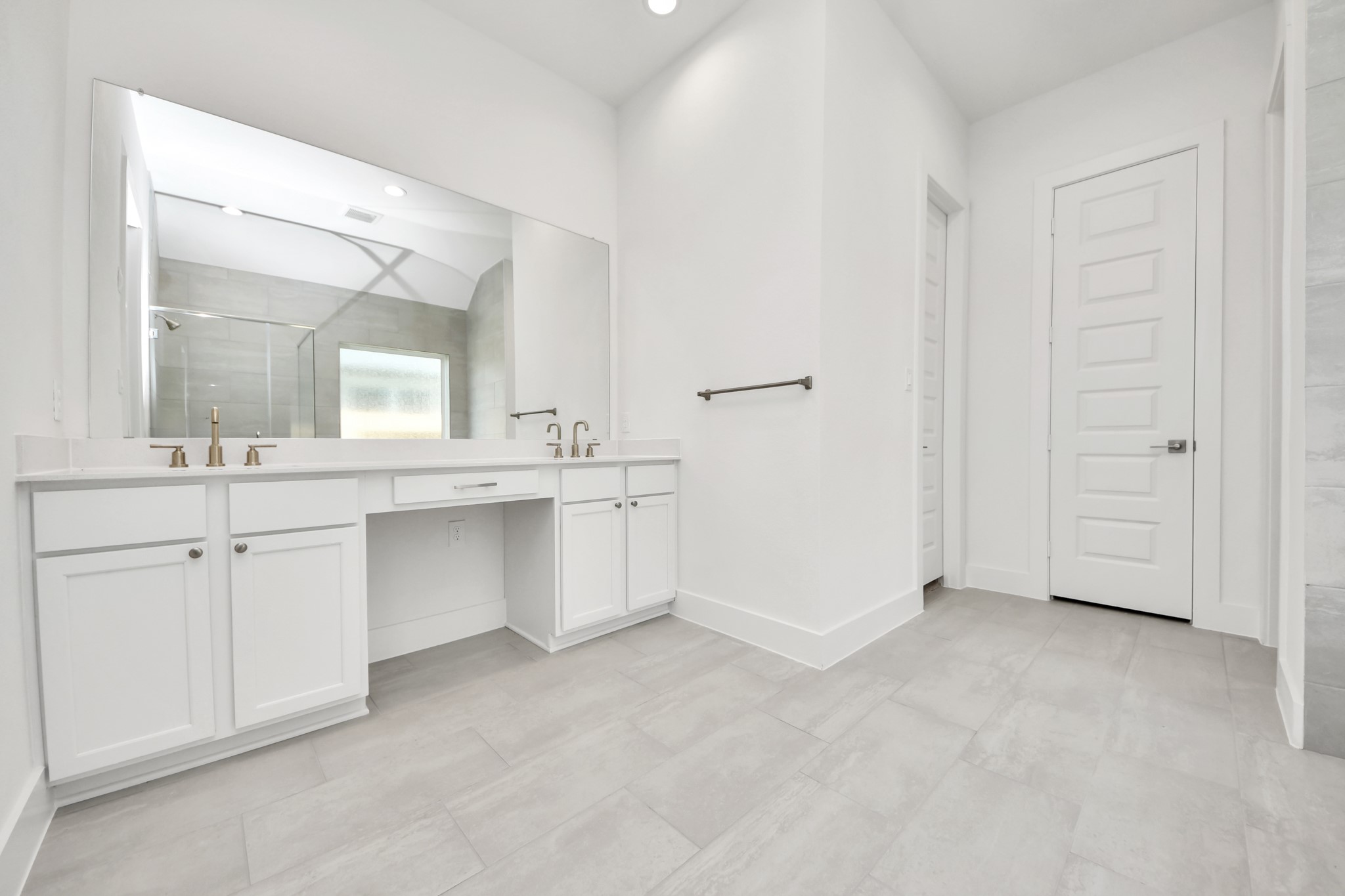 Escape to a spa-like oasis in this primary bathroom. Enjoy a walk-in shower with tile surround, a separate garden tub with custom detailing, and an elegant vanity featuring light countertops, modern hardware, and beautiful recessed lights. Experience luxury and relaxation in every detail. Sample photo of completed home with similar floor plan. Actual colors and selections may vary.