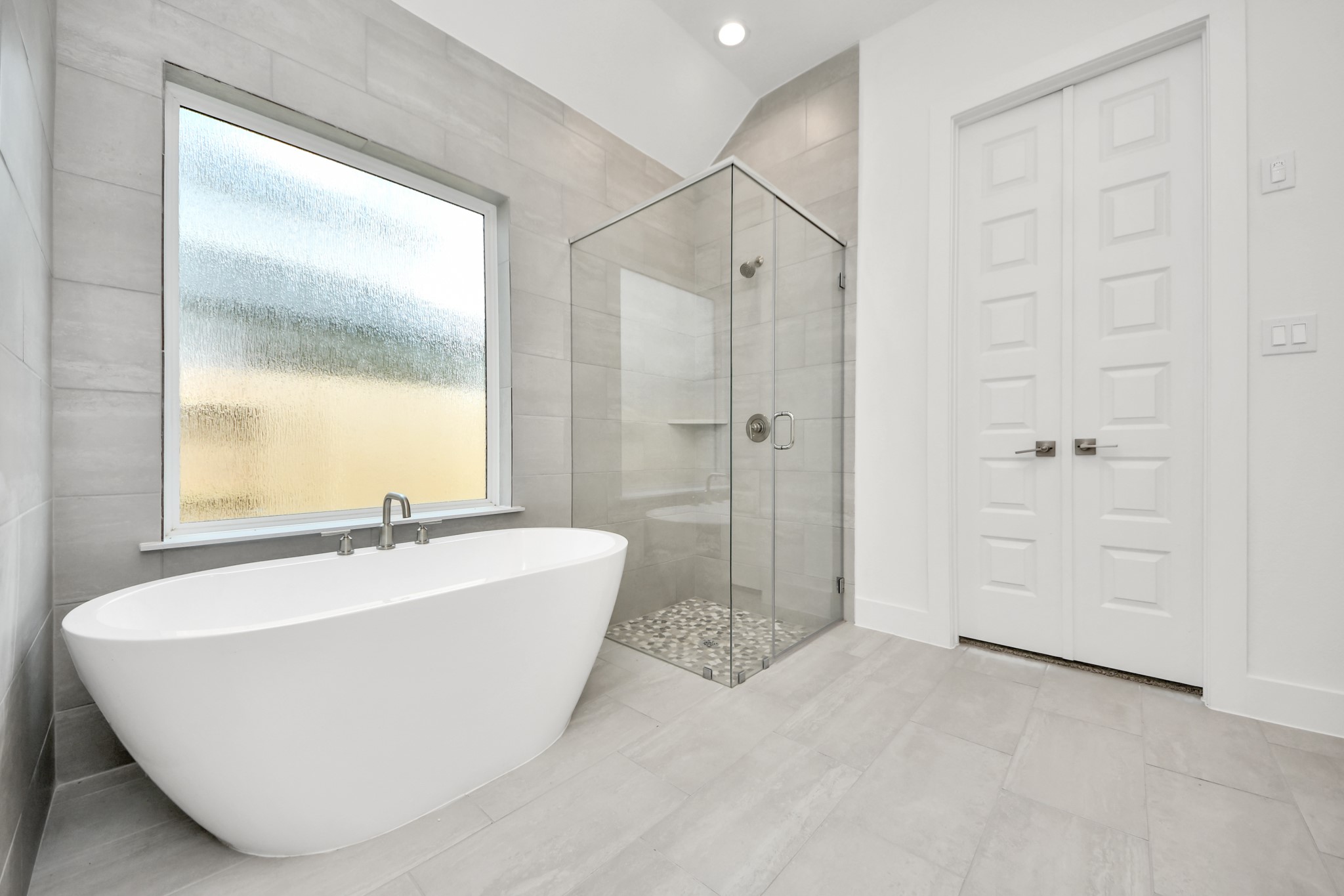 Elevate your daily routine at the elegant vanity, now equipped with double sinks, light countertops, modern hardware, and beautiful recessed lights. Sample photo of completed home with similar floor plan. Actual colors and selections may vary.