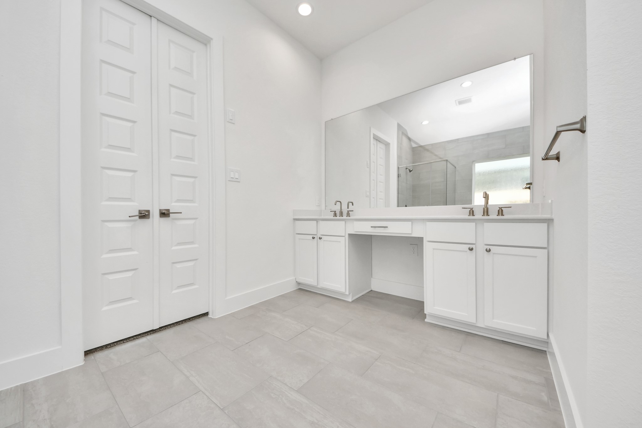 Indulge in a spa-like retreat within the confines of this primary bathroom. Delight in a spacious walk-in shower enveloped in stylish tile surround, unwind in a separate garden tub adorned with custom detailing. Sample photo of completed home with similar floor plan. Actual colors and selections may vary.