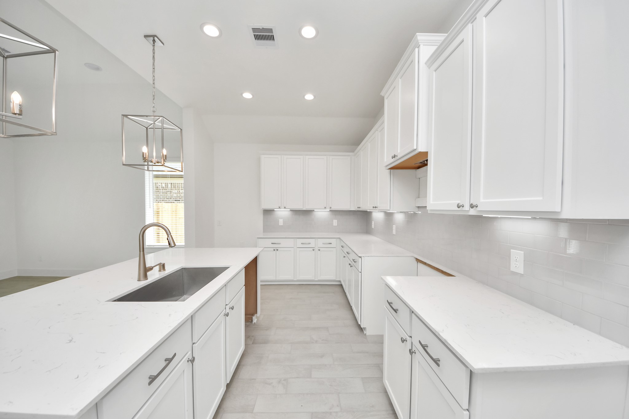 Step into a dream realized with this generously spacious kitchen! A massive granite island takes center stage, complemented by high ceilings and soft-close cabinets. The granite countertops, stainless steel appliances, sleek tile backsplash, and recessed lighting complete the elegant design. Sample photo of completed home with similar floor plan. Actual colors and selections may vary.