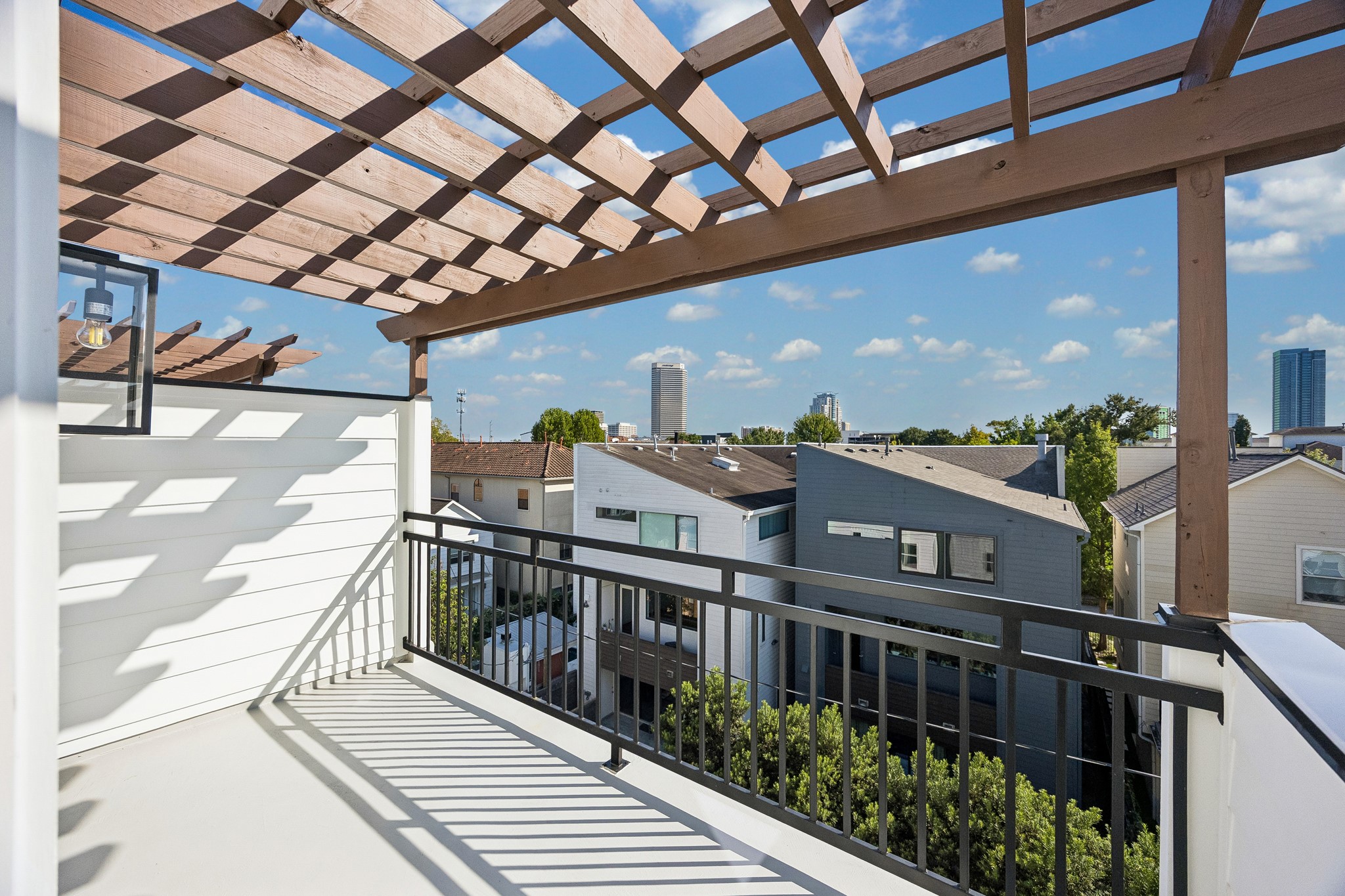 Rooftop terrace  features a pergola and amazing views of the city skyline.