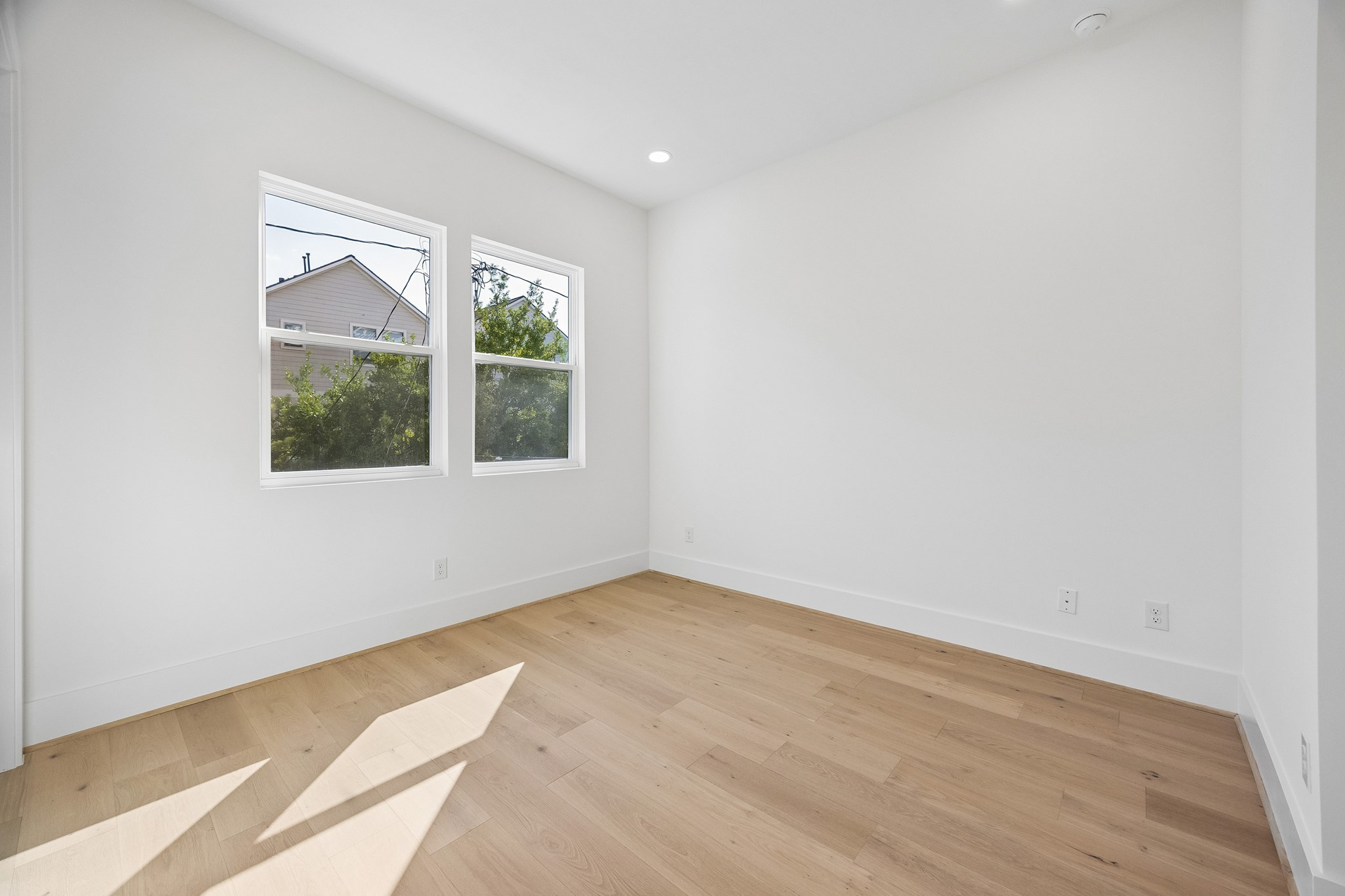 Bedroom #2  features wood flooring, recessed lighting and dual windows.