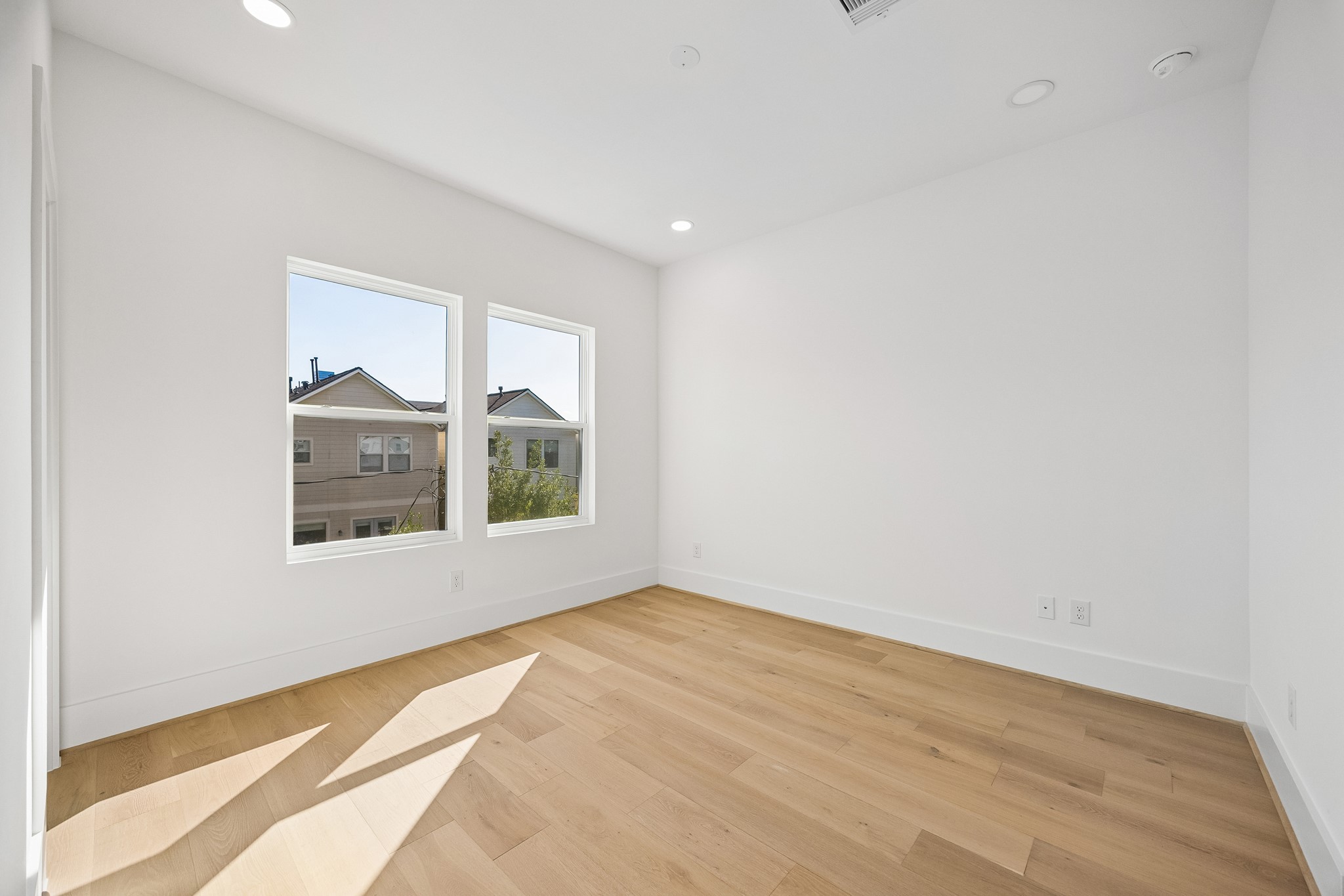 Bedroom #3  features wood flooring, recessed lighting and dual windows.