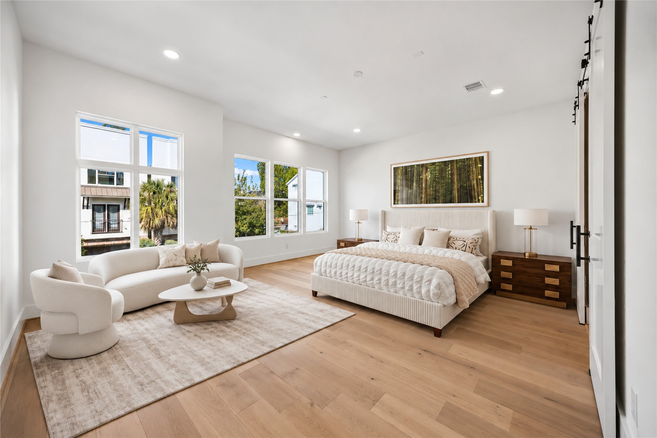 Another view of the primary suite  offers large windows and an abundance of natural light. (virtual staging)