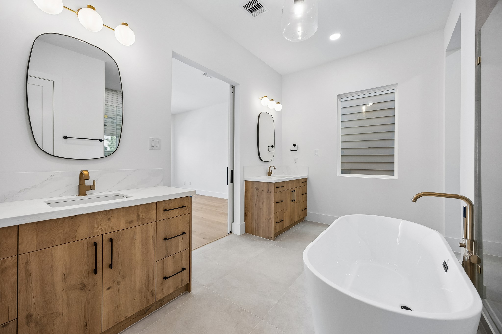 Spa-like primary bath  features dual vanities, a freestanding tub and spacious walk-in shower.