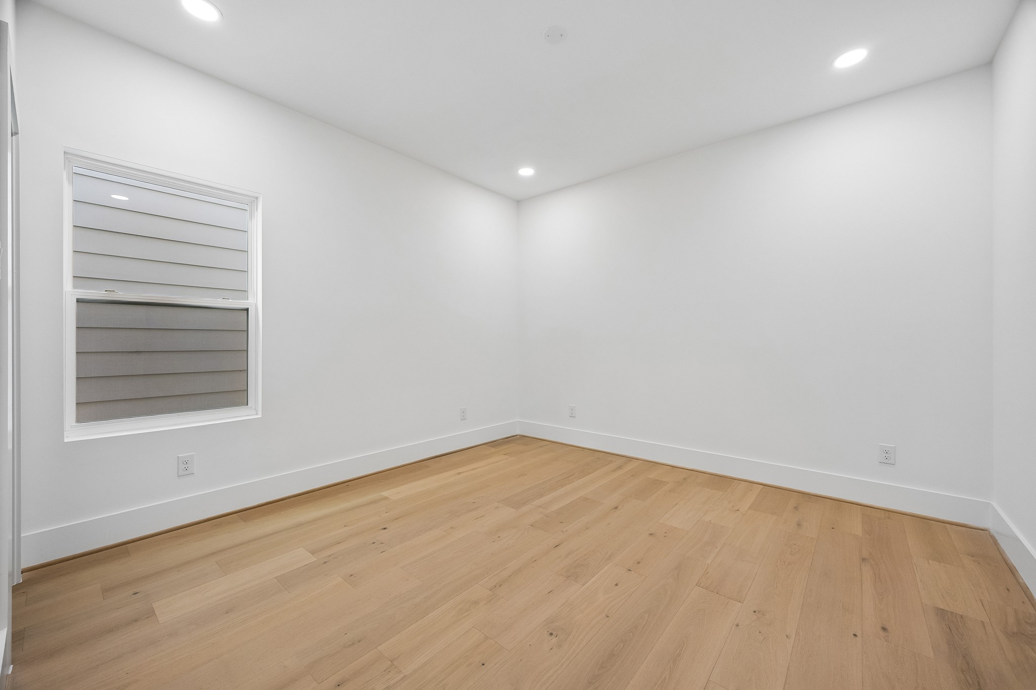 Bedroom #4  features wood flooring and recessed lighting.