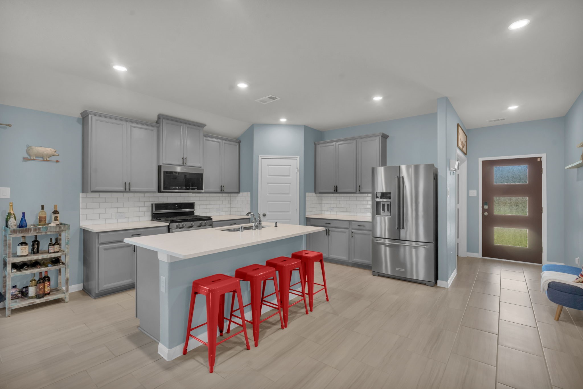 Stunning kitchen features gorgeous cabinetry, a massive center island with breakfast bar seating, stainless steel appliances, and an oversized walk-in pantry. Refrigerator is included.