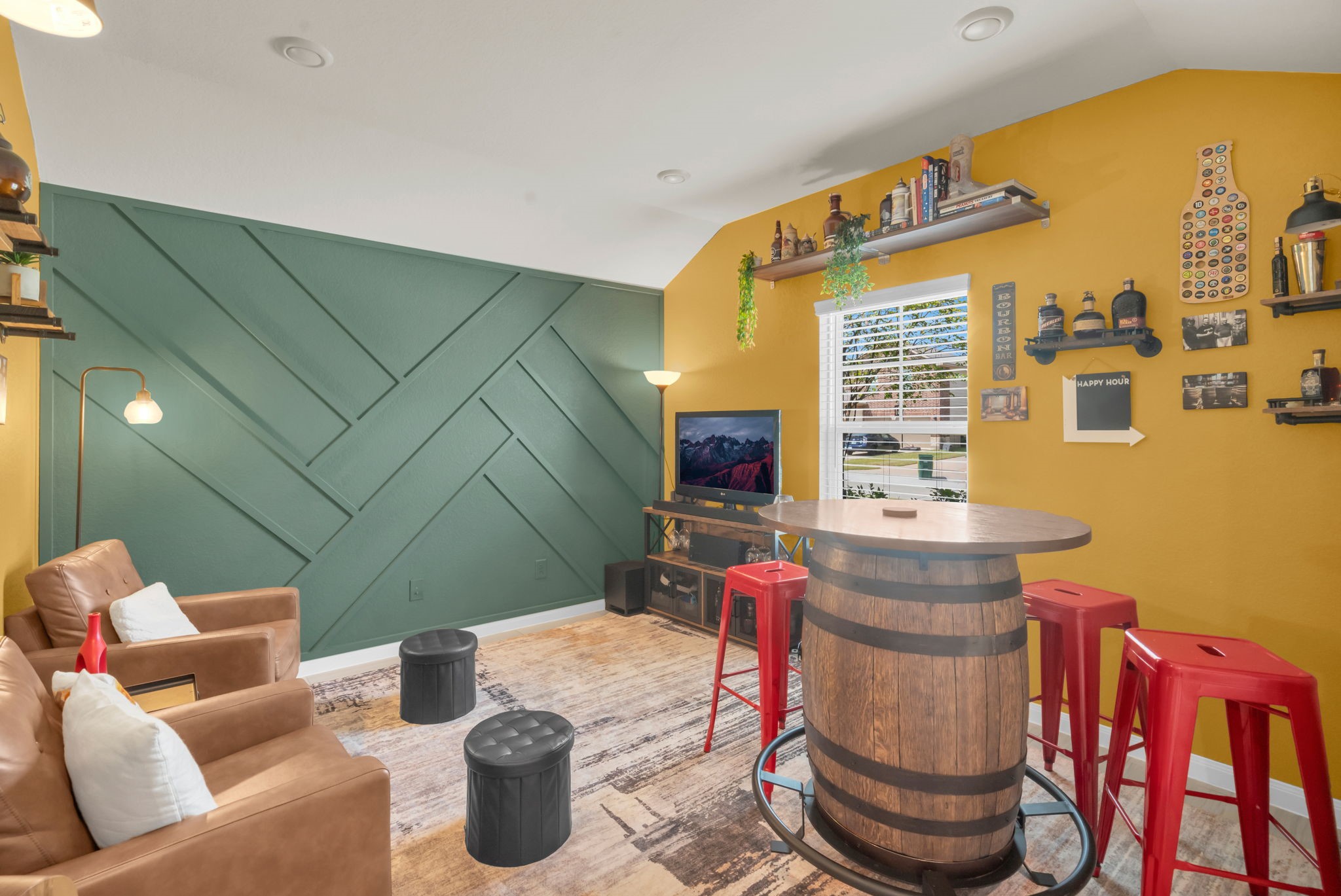 Private home office with bright walls, a stylish accent wall and front yard views.