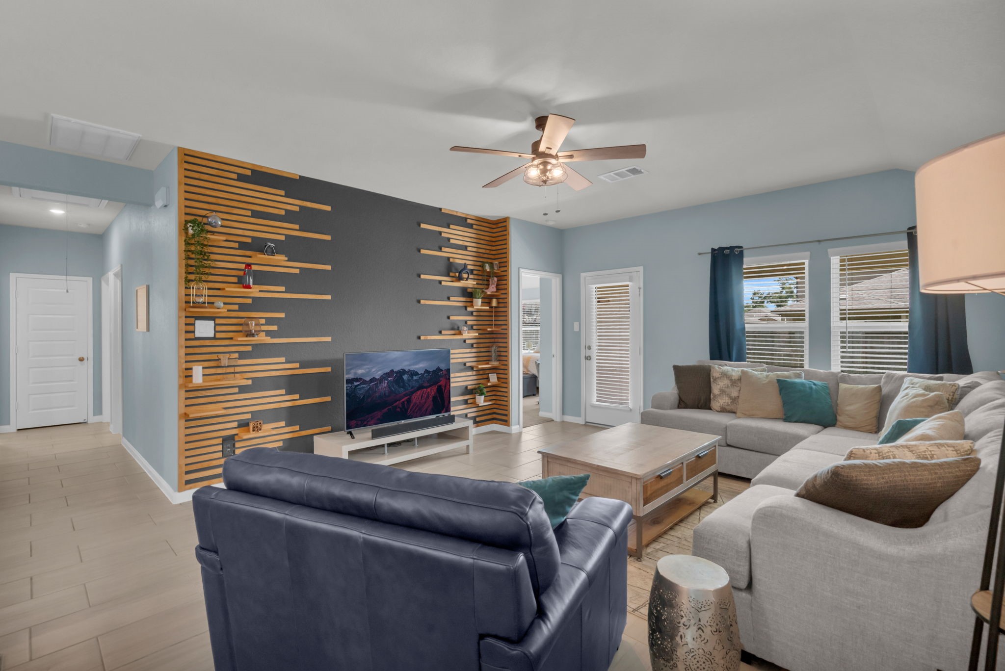Impressive living room features striking custom built-in shelving and beautiful views of the backyard.