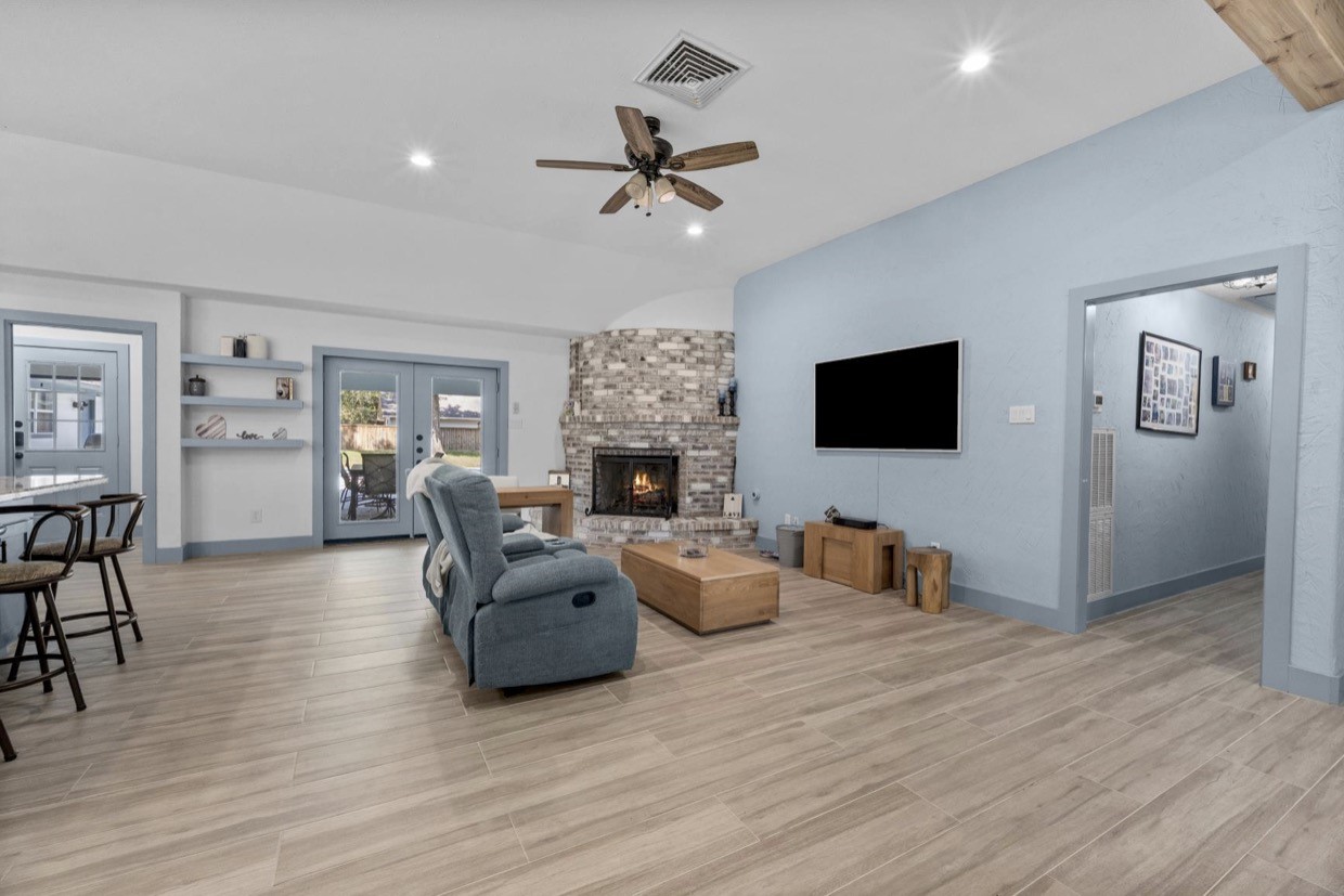 Welcoming living room with a distinctive fireplace, recessed lighting, and a ceiling fan.