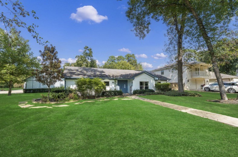 Mature trees and a broad lawn surround the home.