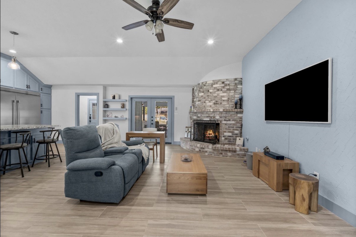 Living room with glass doors leading toward the covered outdoor living area and outdoor kitchen.