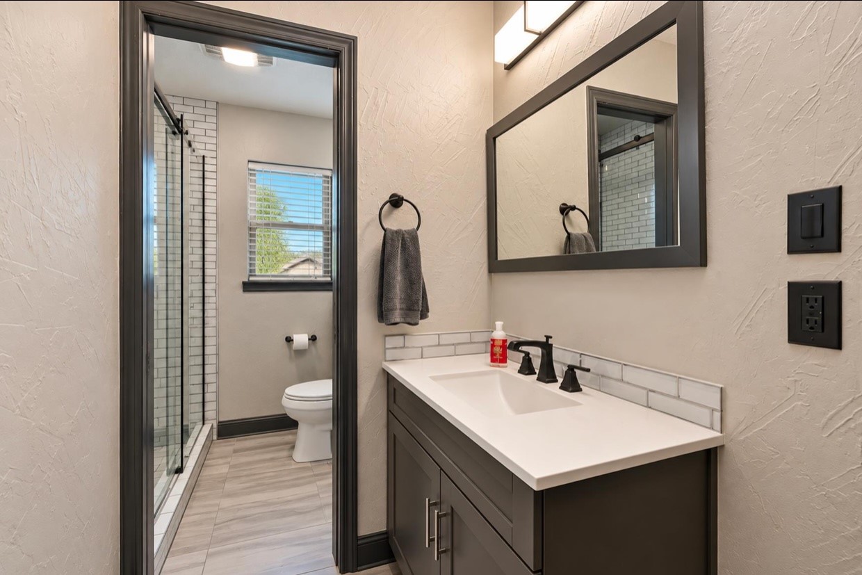 View through the guest-suite bathroom from the vanity toward the shower area.