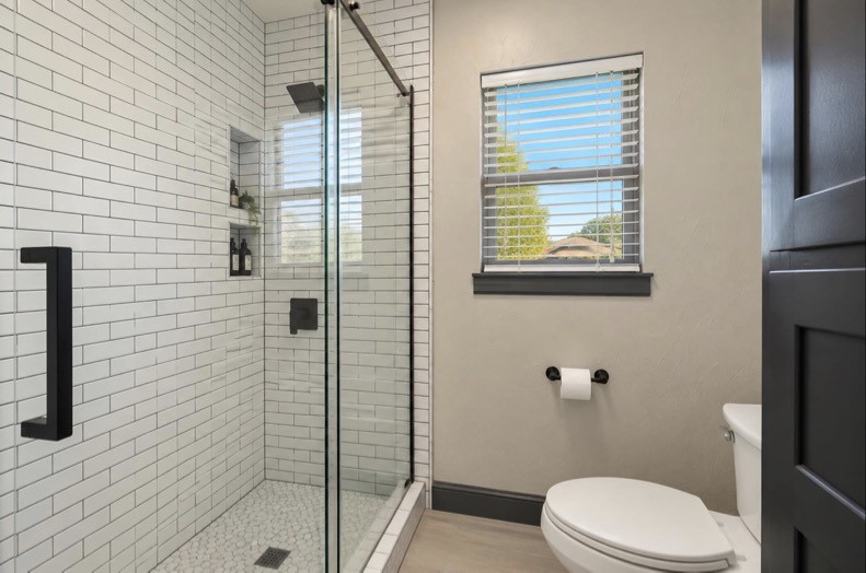 Guest-suite shower with a glass enclosure and white subway tile.