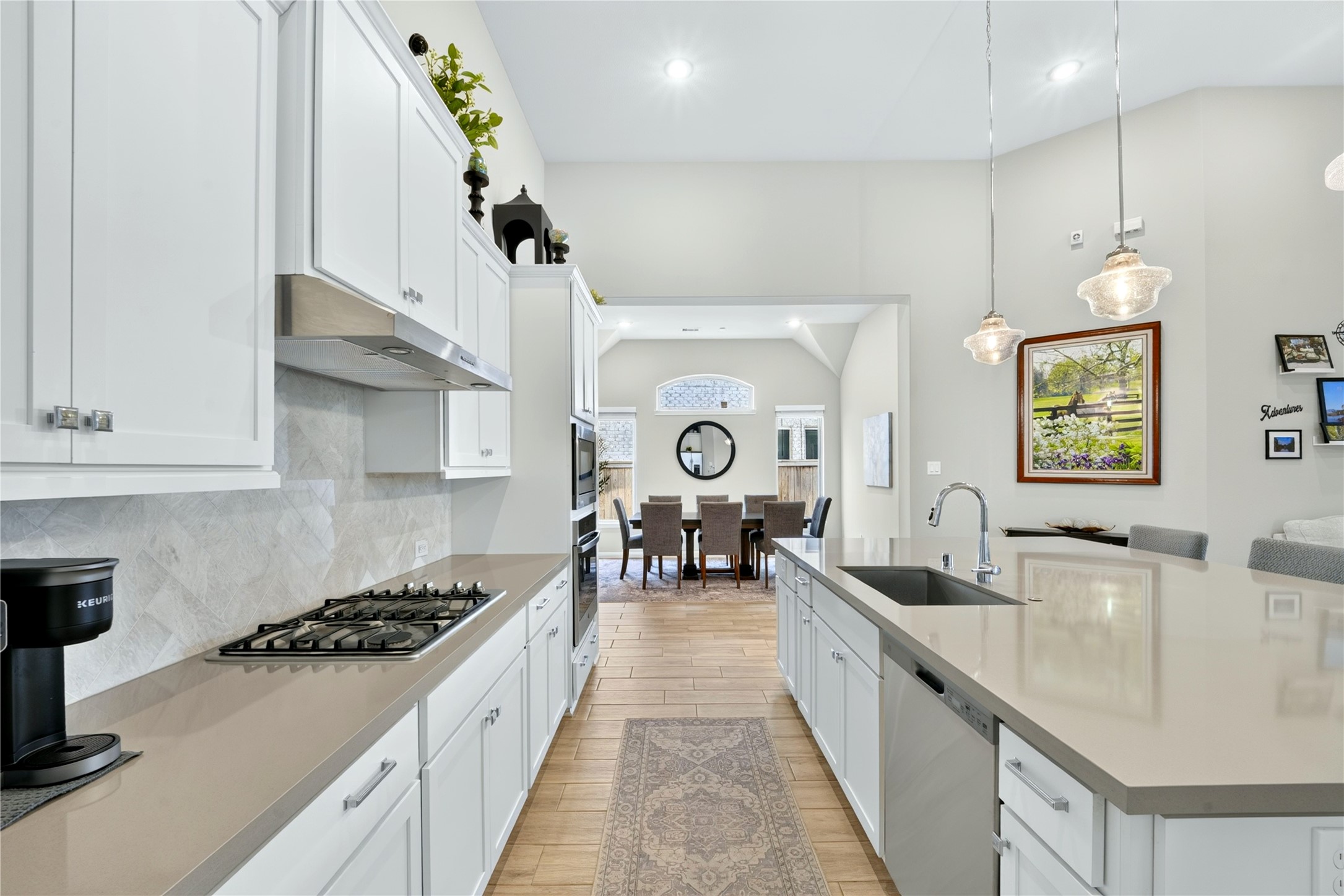 This kitchen was made for connection. A gas cooktop, built-in oven and microwave make cooking effortless, while the oversized sink handles it all with ease. Crisp white cabinets brighten the space, and an open view to the dining room means you are never far from conversation.