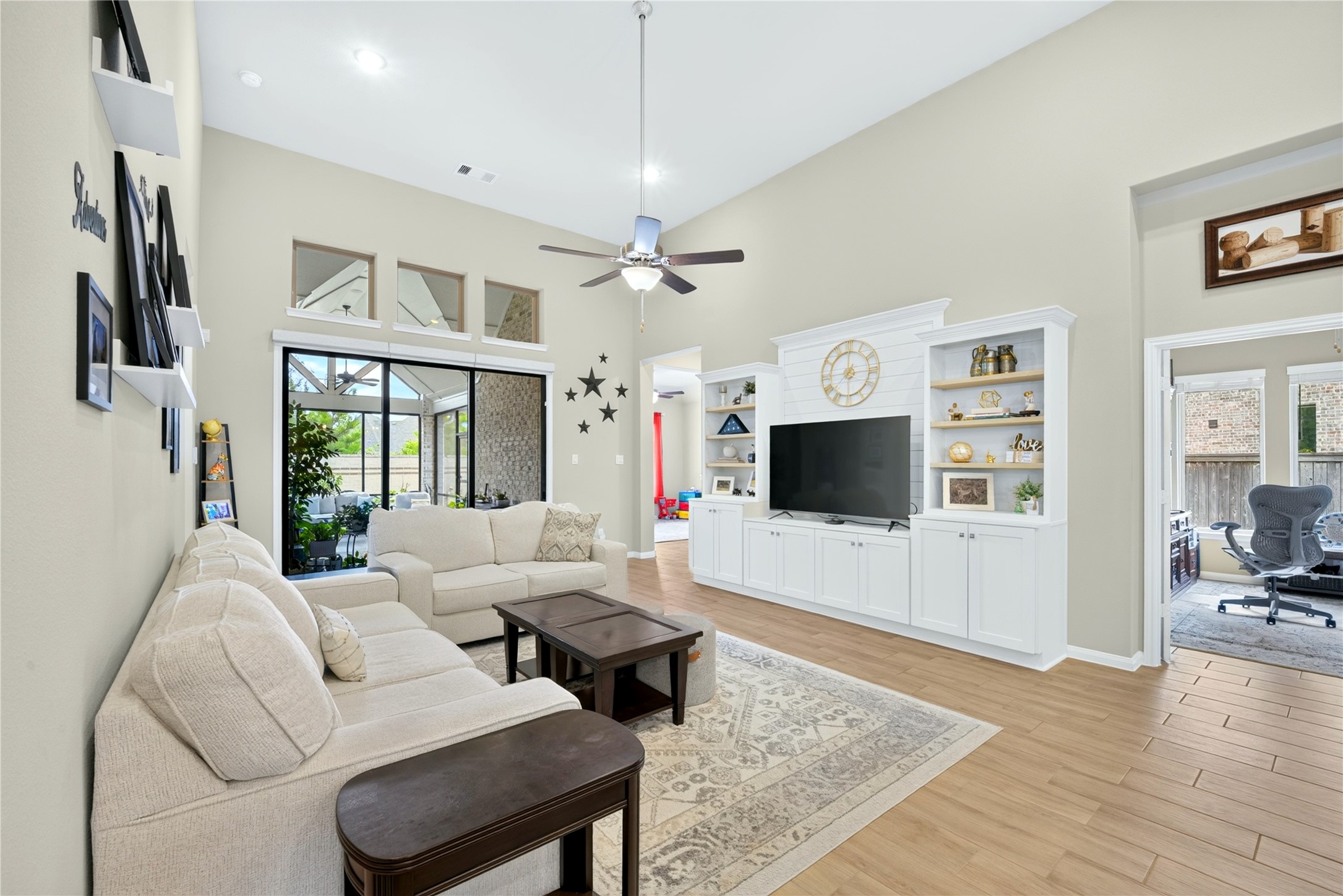Beautiful built-in entertainment center anchors the family room, creating stylish focal point while providing functional space for your television and media components. The neutral toned tile flooring complements the room and adds a charming, cohesive touch.
