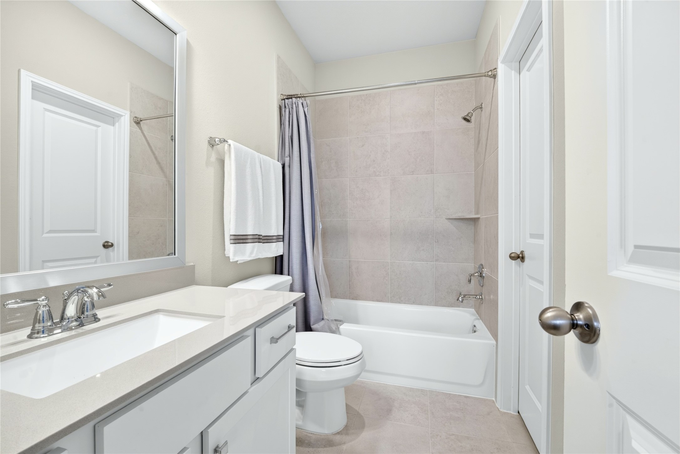 The en-suite bath featuring single vanity, granite counters, soaking tub, designer mirror and spacious walk-in closet.