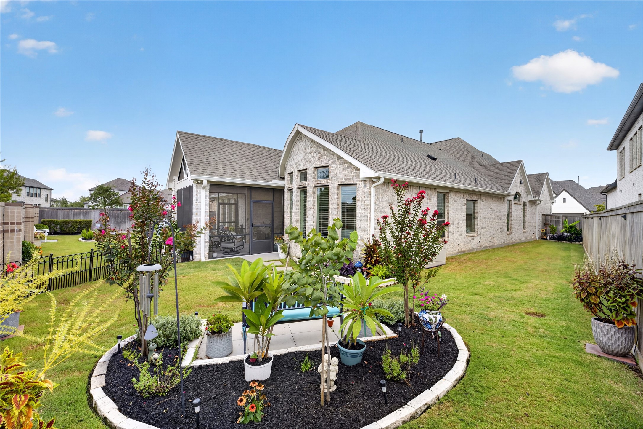 Beautifully landscaped backyard with spacious areas, mature plantings and a charming garden bed.