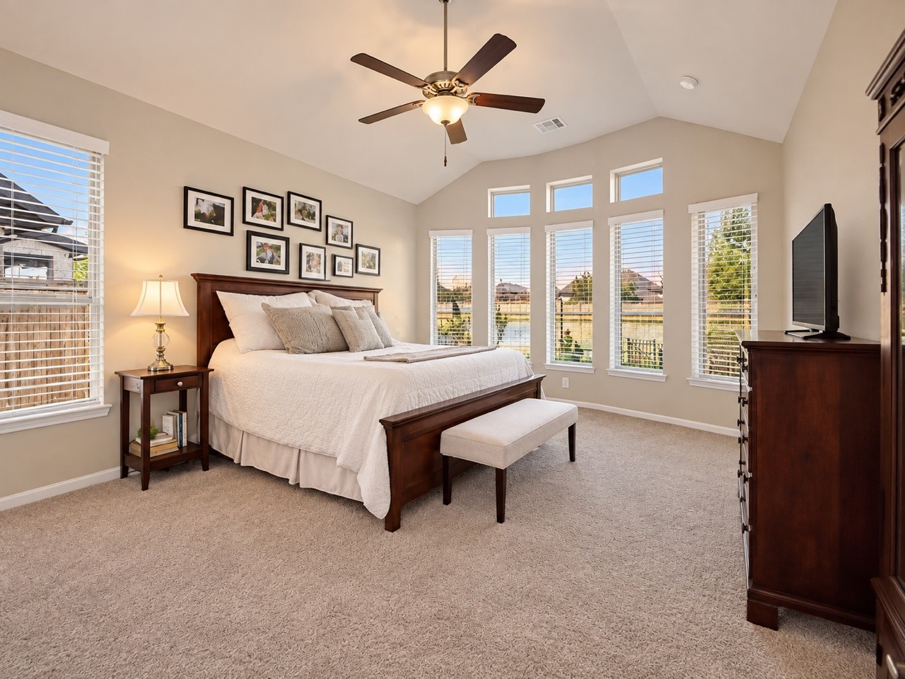 Spacious primary bedroom tucked at the back of the home, offering peaceful backyard views, abundant windows, high ceilings, and beautiful natural light.