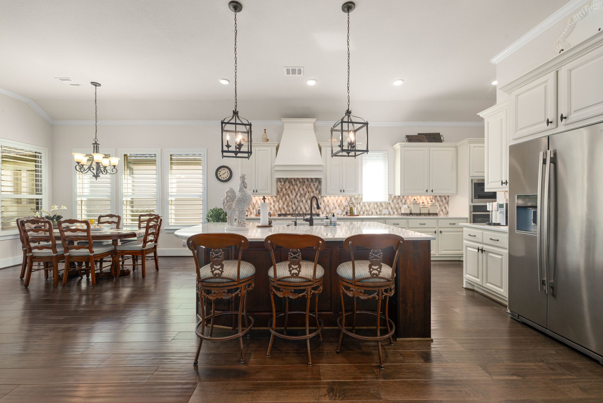 Bright, beautiful, and spacious! This gorgeous kitchen features an oversized quartz island with seating for three, elegant pendant lighting, designer backsplash, and a sun-filled dining area perfect for gathering with family and friends!
