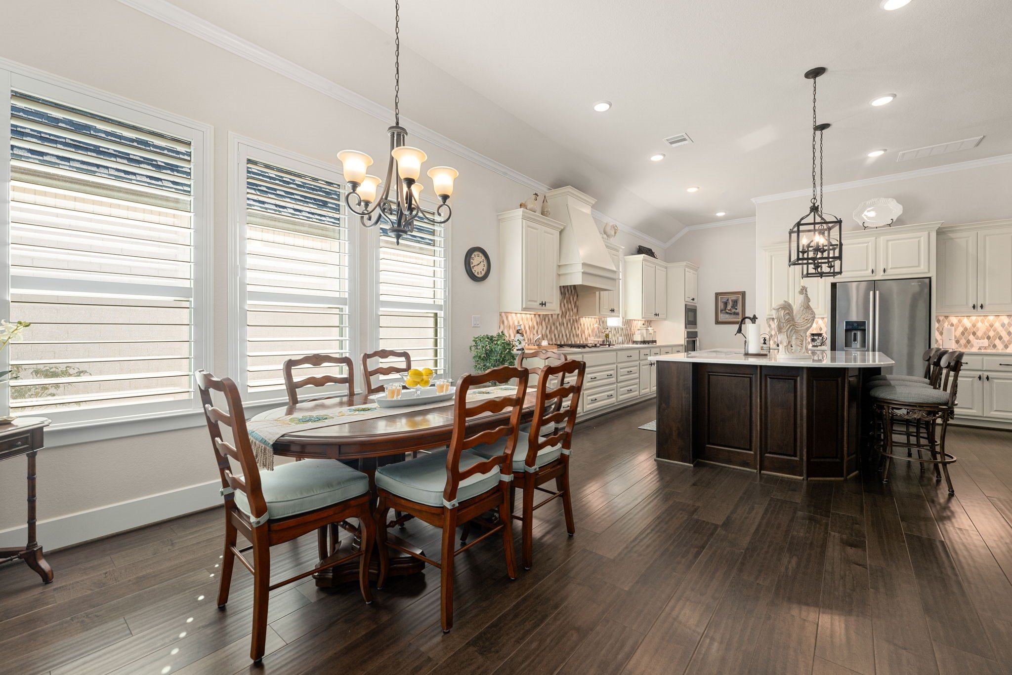 Enjoy casual dining surrounded by natural light from beautiful plantation-shuttered windows! This inviting dining space flows effortlessly into the gorgeous kitchen!
