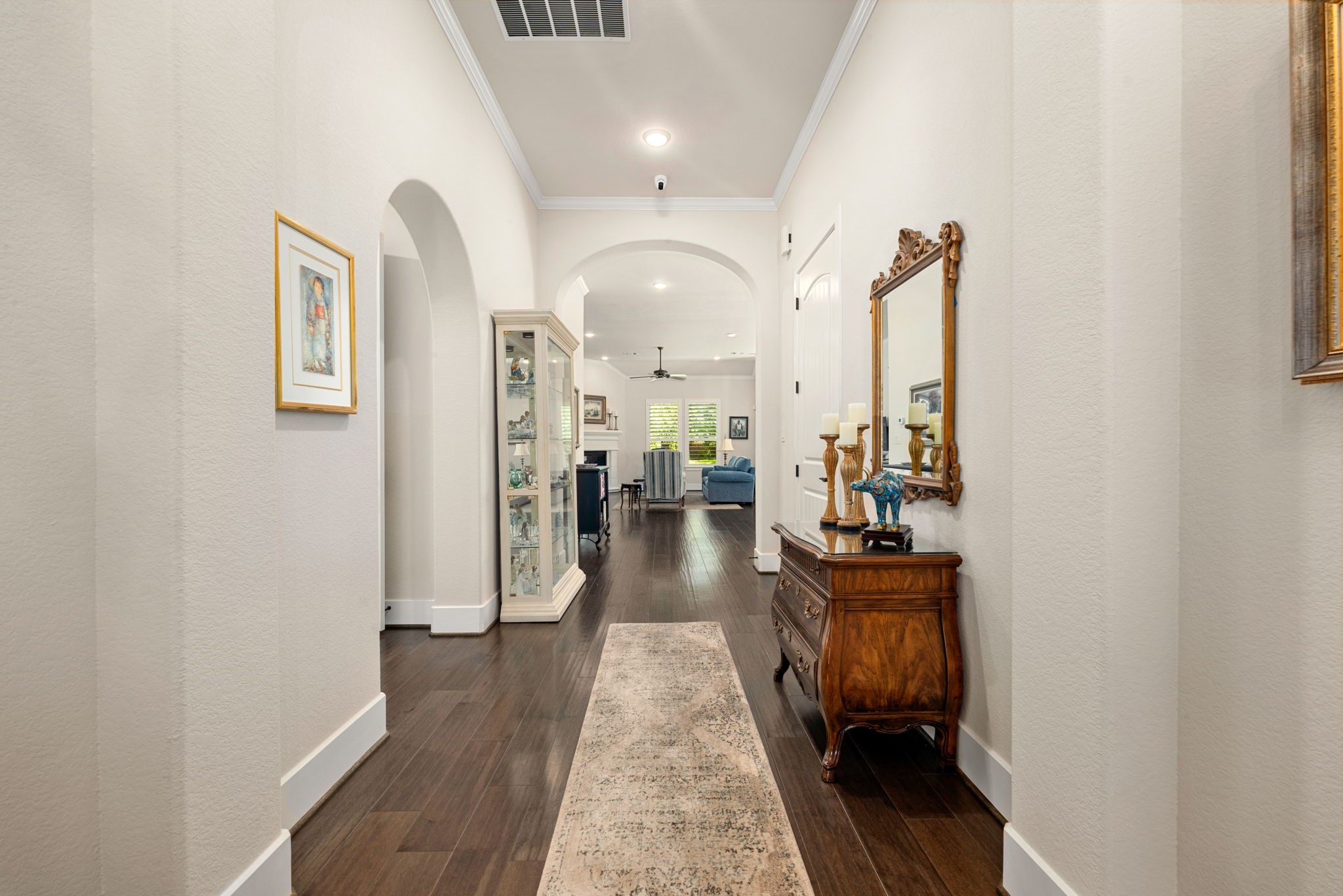 Beautiful wood flooring and graceful archways lead you through the spacious entry and into the inviting living area, creating a wonderful sense of openness and flow!