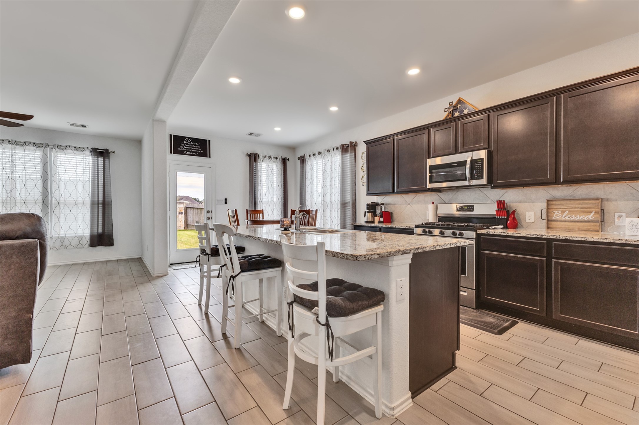 This bright open kitchen features an island as spacious prep area, serving bar and adds extra seating for entertaining.