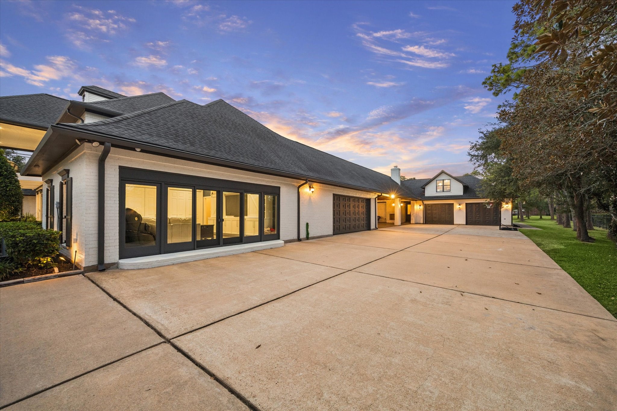 View of sliding doors to family room, two car garage, porte-cochere and detached garage.