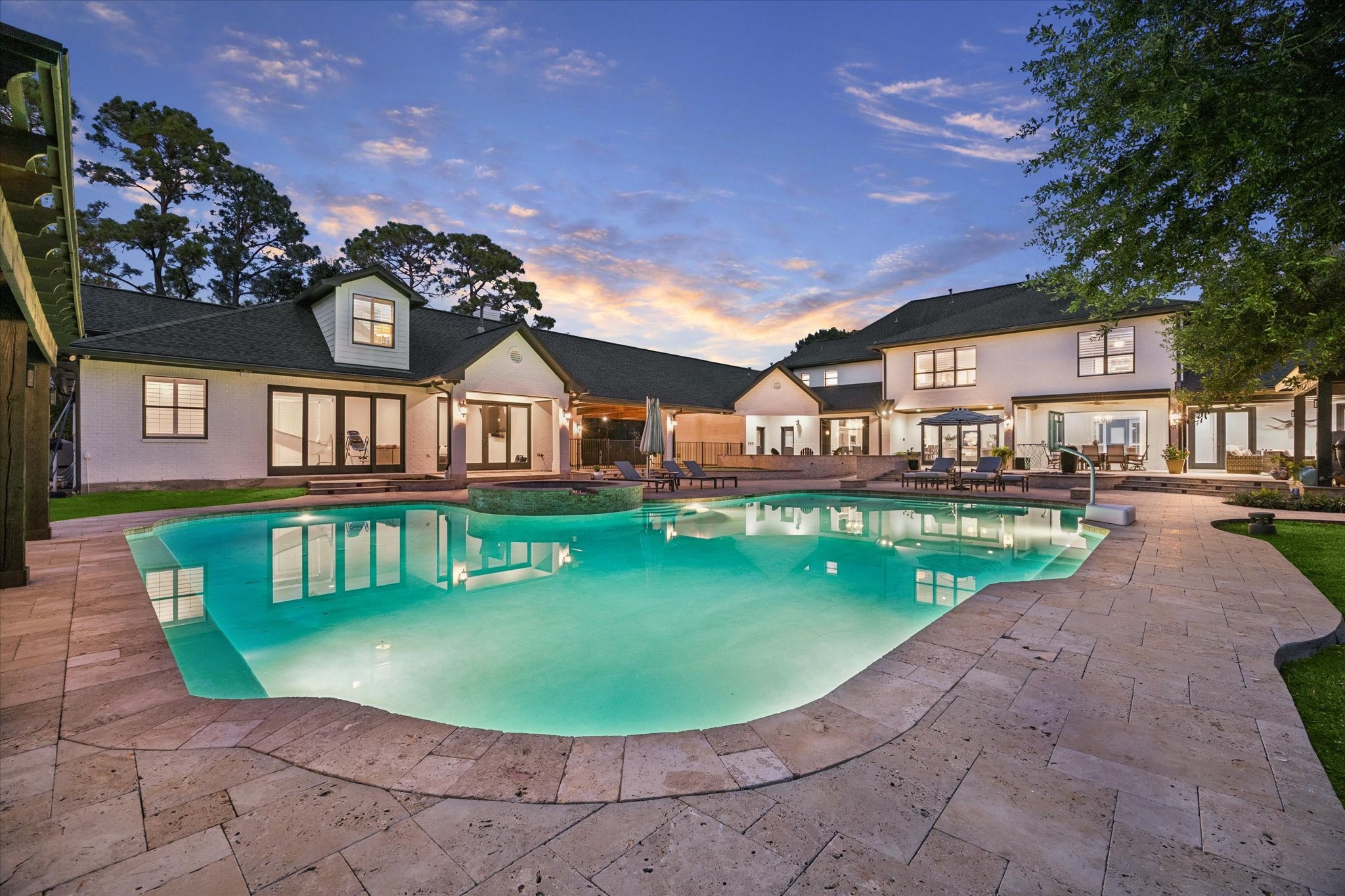 Luxurious estate featuring a stunning backyard oasis with a sparkling pool, expansive patio, and elegant architecture, perfect for entertaining and relaxation.