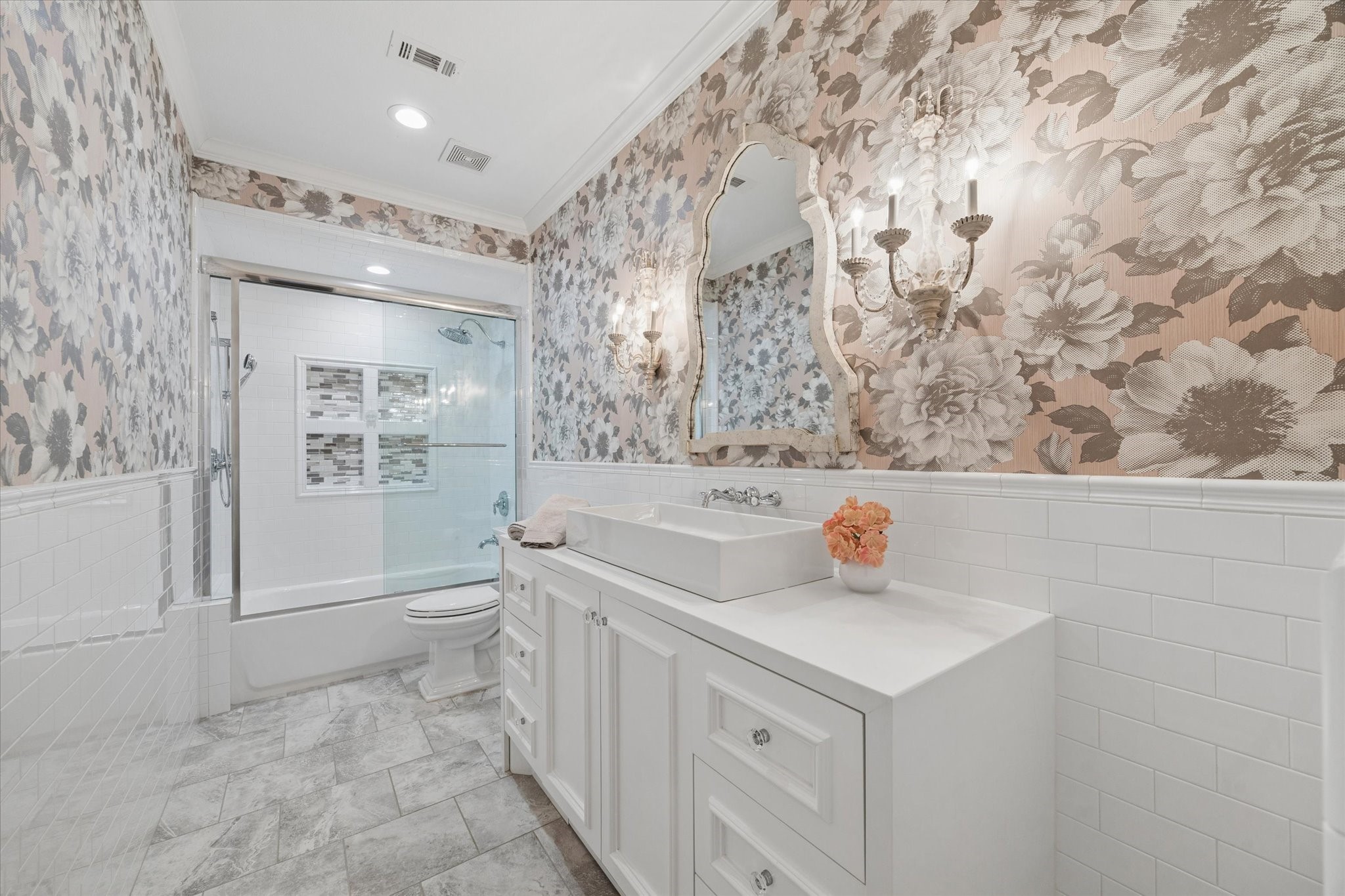 Charming bathroom ensuite featuring beautiful wallpaper, custom cabinetry and a clever pullout step for little ones to reach the sink.
