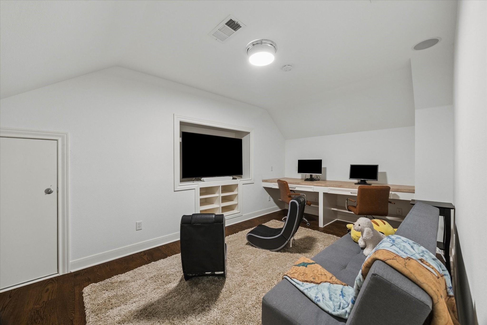 Cozy room featuring a built-in desk and attic access ideal for work or play.