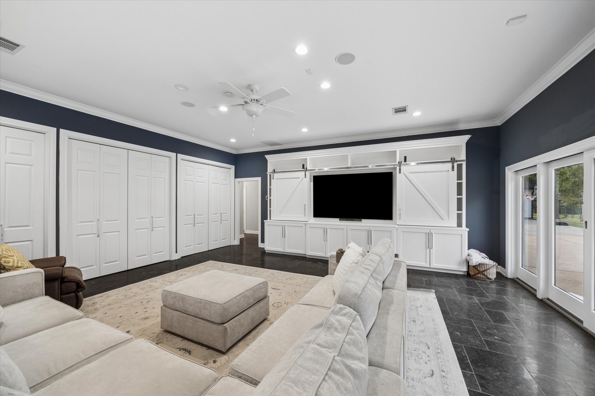Family or game room off of the kitchen with ample storage and entertainment center. The glass sliding doors lead to the side of the house ideal for entertaining.