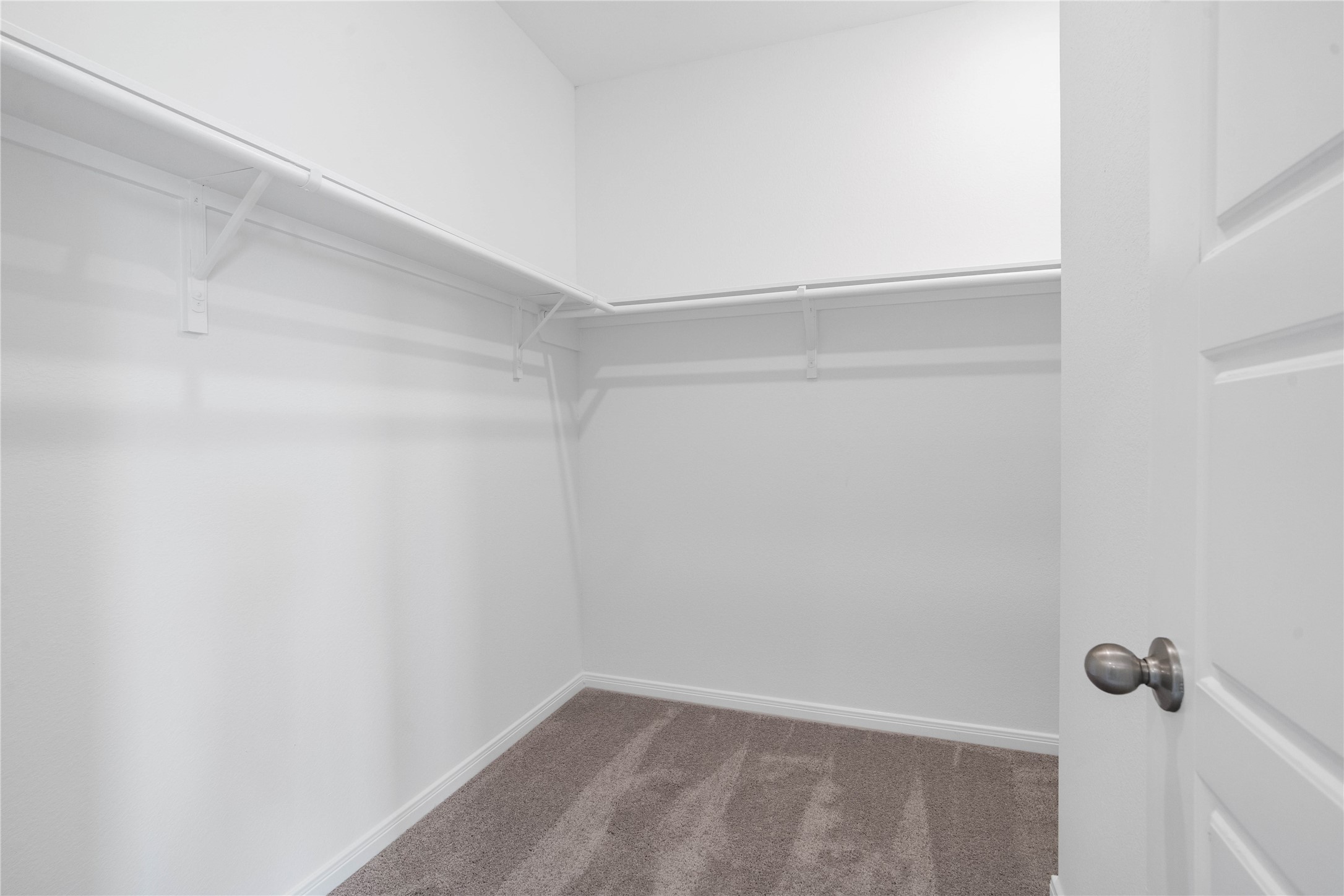 The primary walk-in closet features high shelving for seasonal storage while keeping your daily essentials within reach.