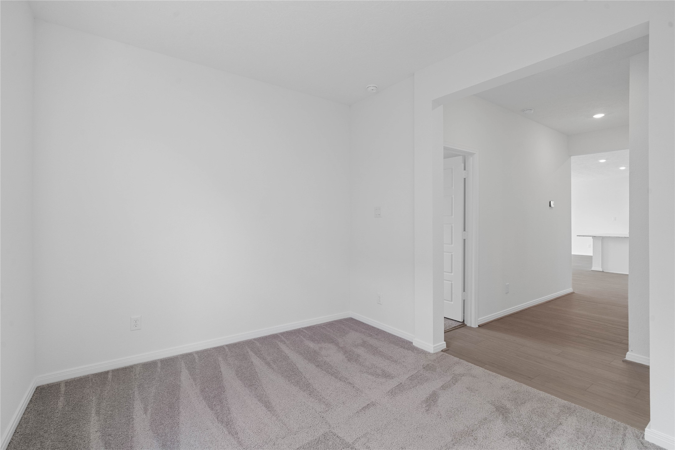 Additional view from Den into hallway. On the left is the entrance into the primary bedroom suite. The Great Room is beyond the hallway.