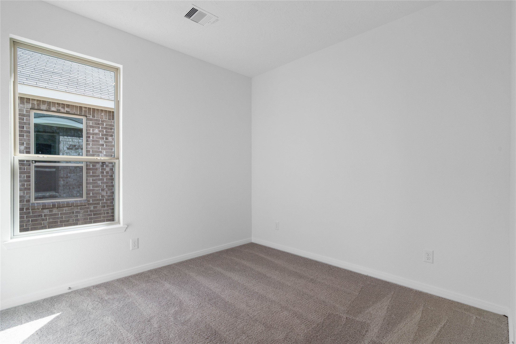 The handsome Den features plush carpet flooring, high ceilings, large window and neutral paint.