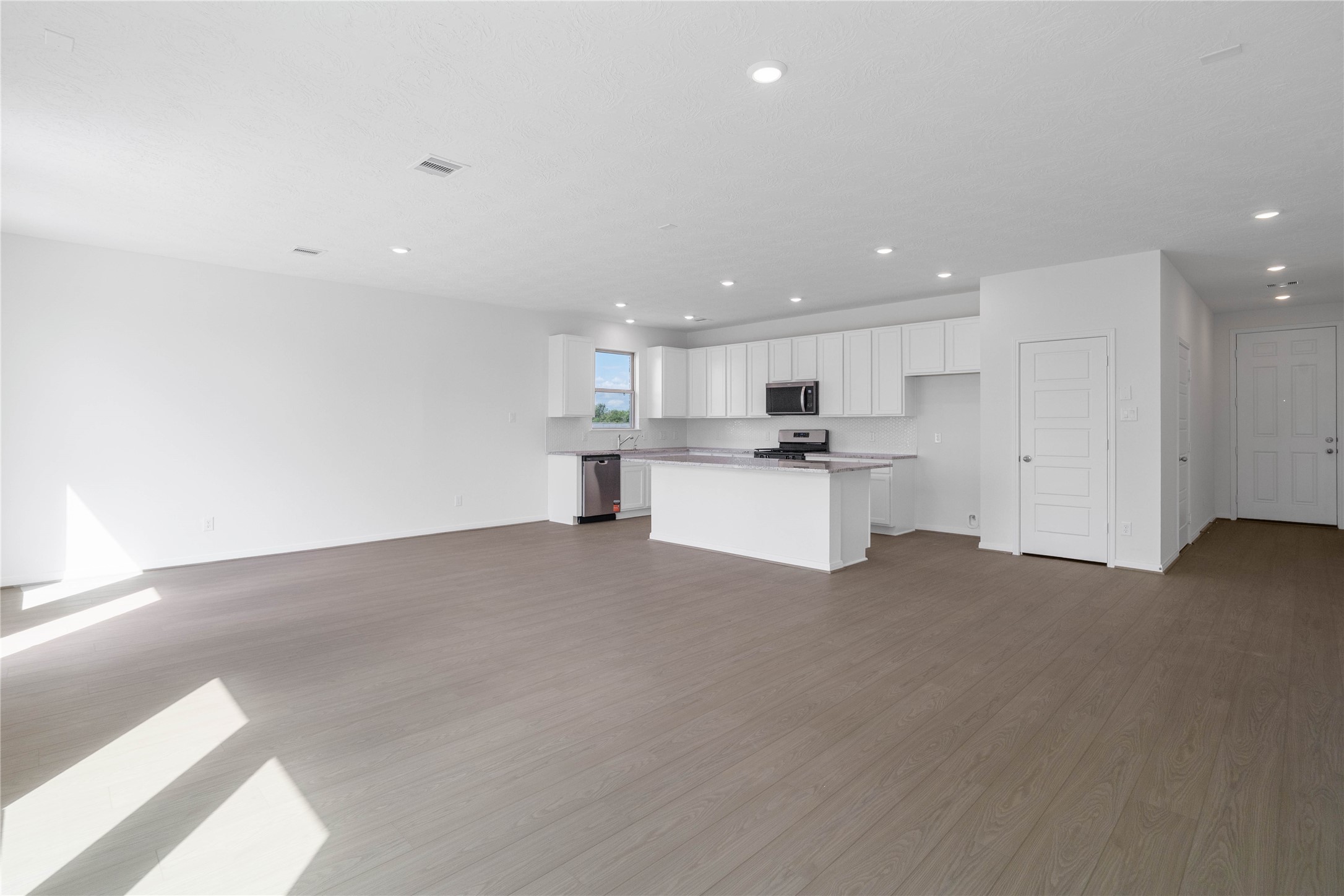 Experience the ultimate in open-concept living with this expansive and sun-drenched main floor layout. The seamlessly connected space provides a versatile footprint, tying the kitchen and living areas together into one cohesive environment.
