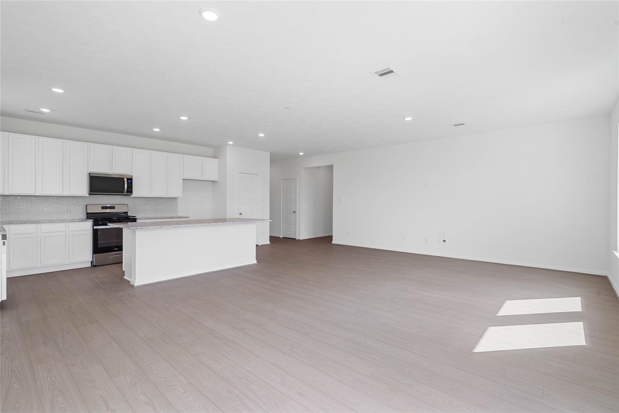 From the dining area looking out to kitchen and hallway to bedrooms and bathrooms.