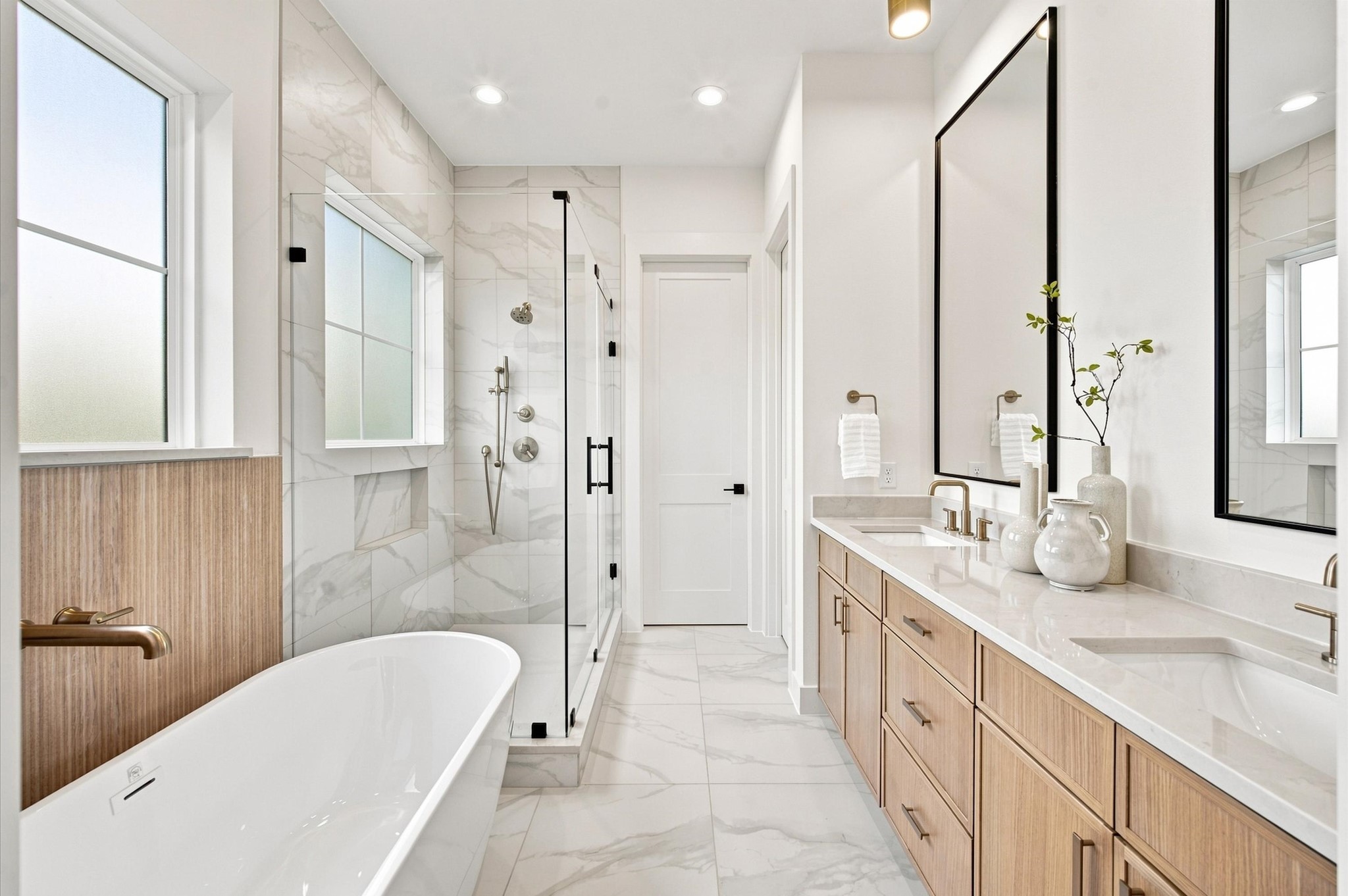 Primary bathroom featuring dual sinks, a soaking tub and a shower.