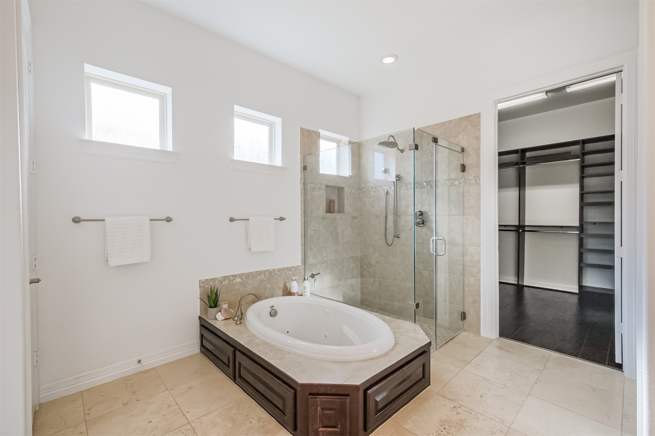 Spacious primary bath features soaking jetted tub and separate shower. High windows ensure plenty of natural light and privacy.