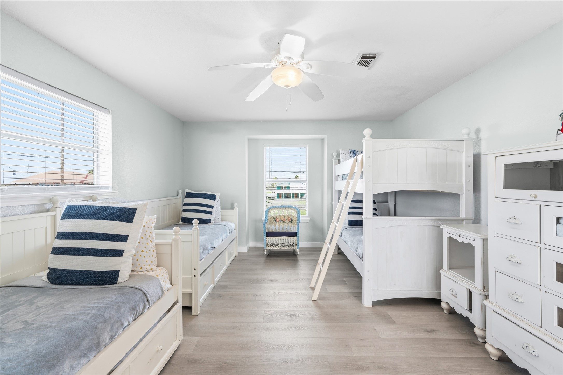 Bright and inviting bedroom featuring twin trundle beds and a bunk bed.
