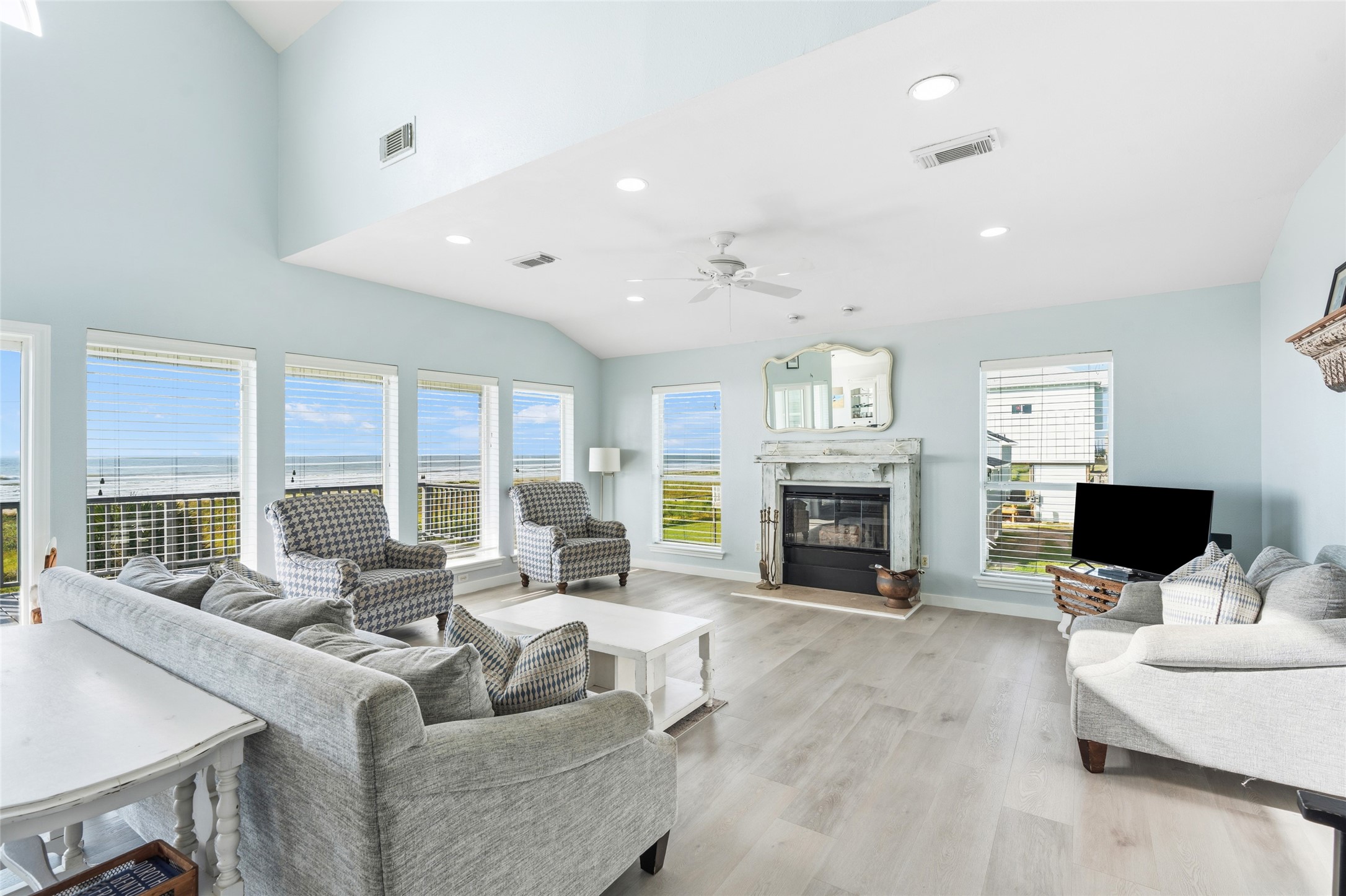 Living room features large windows with ocean views, and a cozy fireplace, ideal for the winter days at the beach!